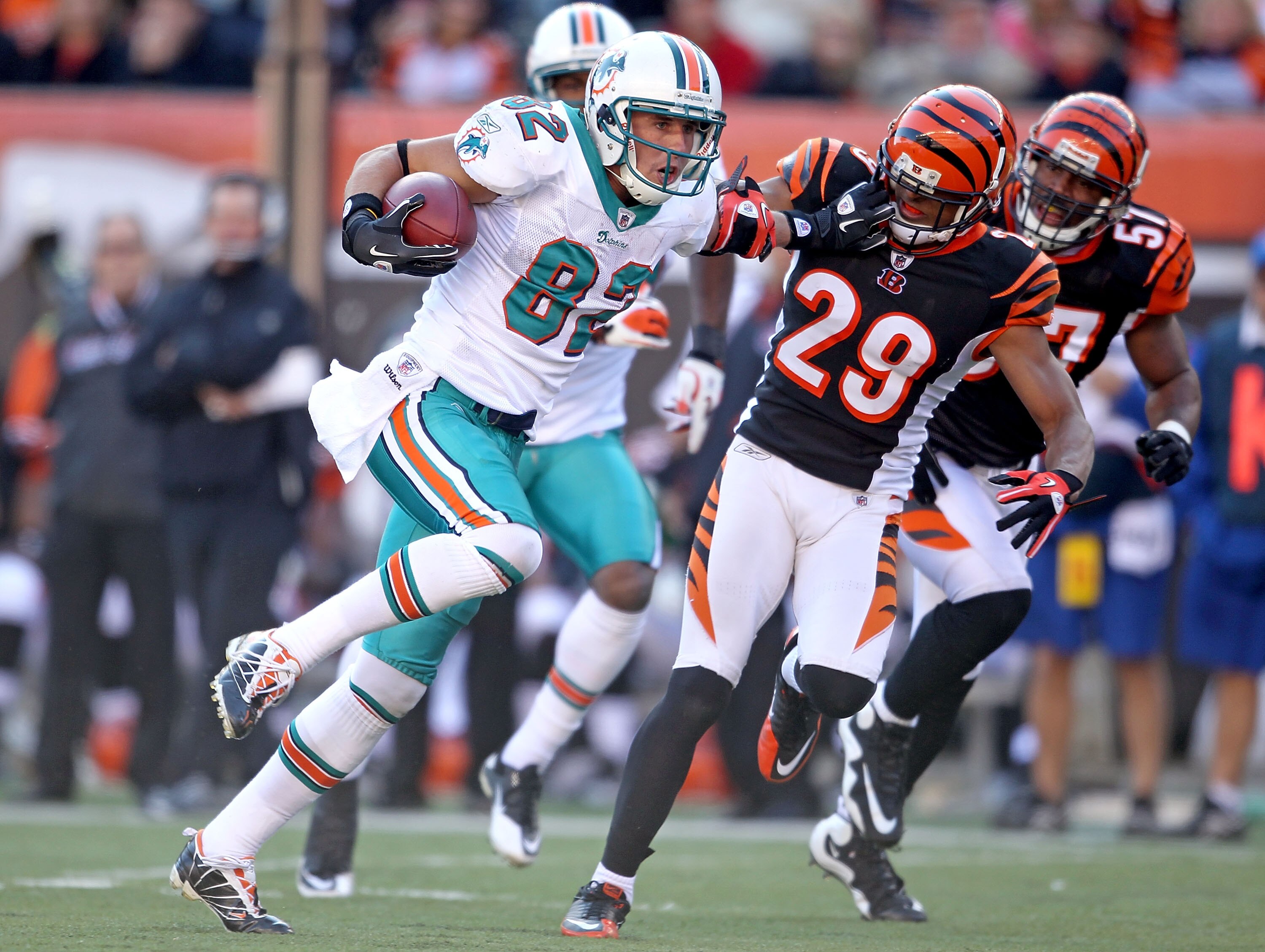 CINCINNATI - OCTOBER 31:  Brian Hartline #82 of the Miami Dolphins runs with the ball while defended by Leon Hall #29  of the Cincinnati Bengals during the NFL game at Paul Brown Stadium on October 31, 2010 in Cincinnati, Ohio.  (Photo by Andy Lyons/Getty