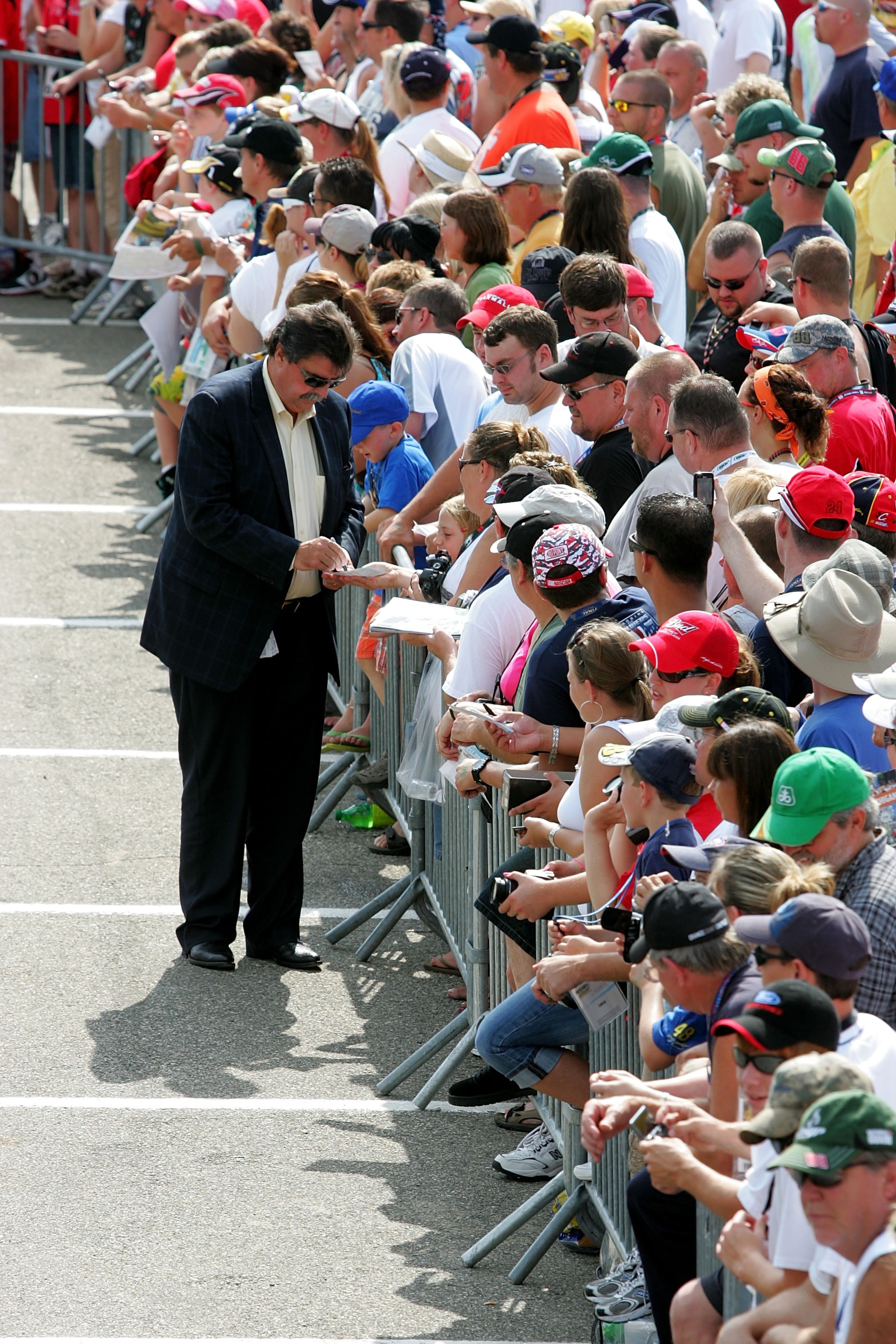 BROOKLYN, MI - AUGUST 15:  NASCAR President Mike Helton signs autographs for fans during the NASCAR Sprint Cup Series CARFAX 400 at Michigan International Speedway on August 15, 2010 in Brooklyn, Michigan.  (Photo by Jerry Markland/Getty Images for NASCAR