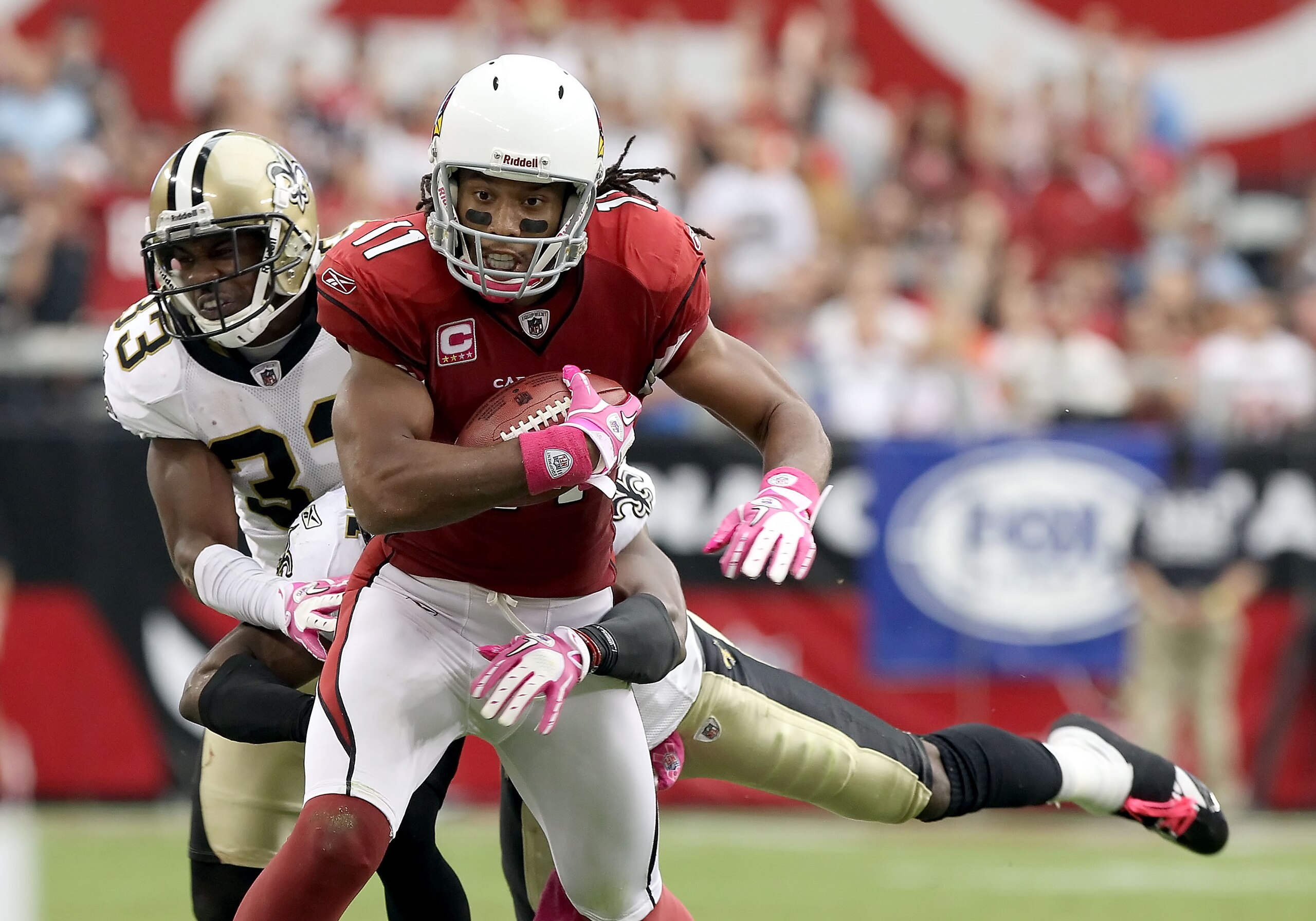 GLENDALE, AZ - OCTOBER 10:  Wide receiver Larry Fitzgerald #11 of the Arizona Cardinals runs with the football after a reception past Jabari Greer #33 of the New Orleans Saints during the NFL game at the University of Phoenix Stadium on October 10, 2010 i