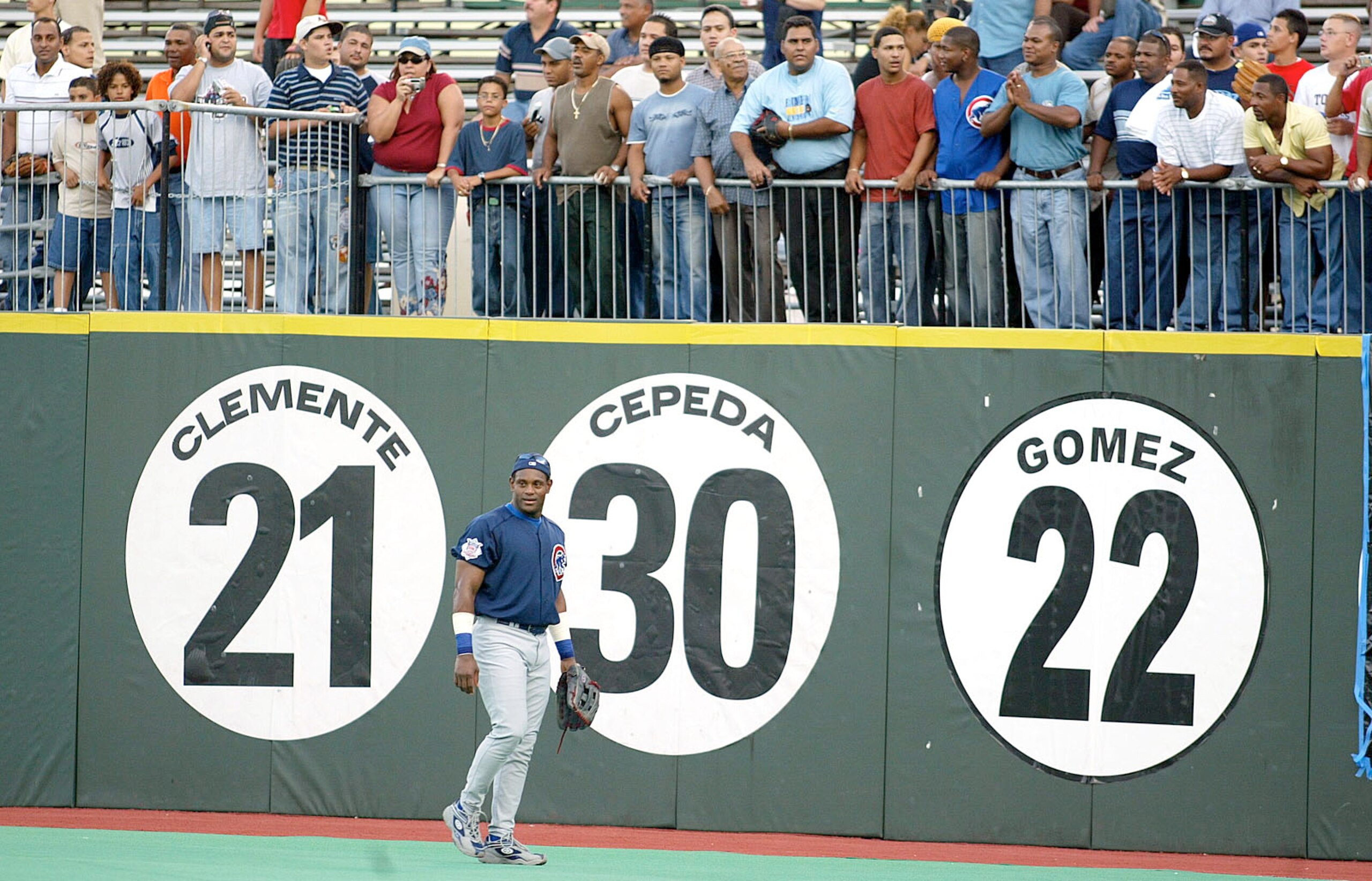 SAN JUAN, PUERTO RICO - SEPTEMBER 9:  ***PUERTO RICO OUT***INTERNET OUT**  Sammy Sosa #21 of the Chicago Cubs walks past signs which pay tribute to Roberto Clemente #21, Orlando Cepeda #30 and Ruben Gomez #22 prior to the Cubs game against the Montreal Ex