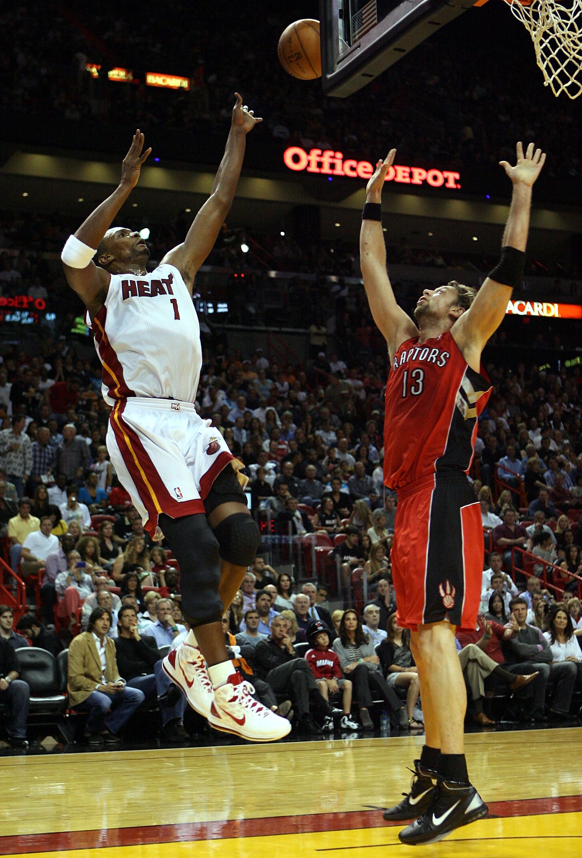 MIAMI - NOVEMBER 13:  Forward Chris Boah #1 of the Miami Heat is defended  by David Anderson #13 of the Toronto Raptors at American Airlines Arena on November 13, 2010 in Miami, Florida. NOTE TO USER: User expressly acknowledges and agrees that, by downlo