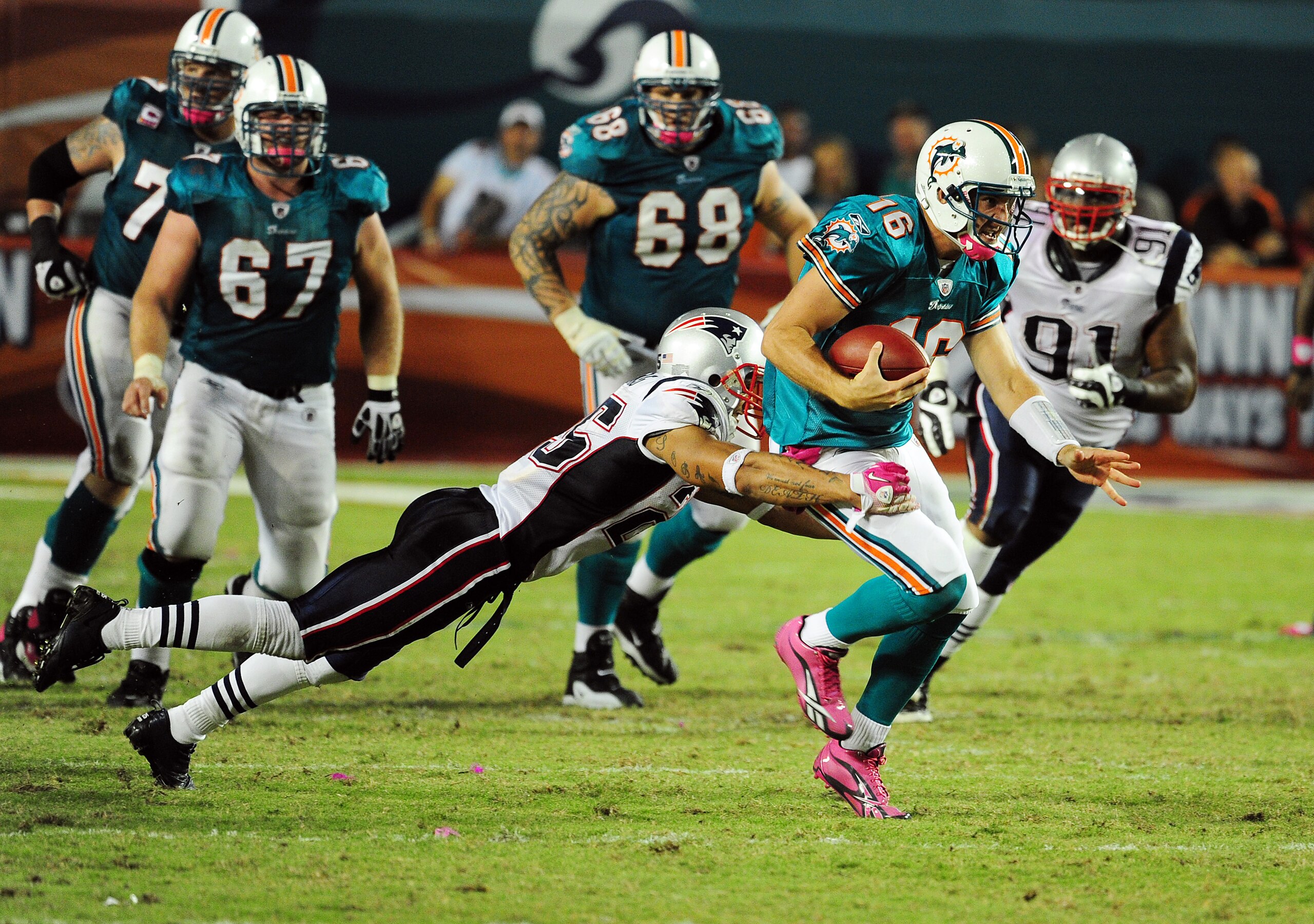 MIAMI - OCTOBER 4: Tyler Thigpen #16 of the Miami Dolphins scrambles against Patrick Chung #25 of the New England Patriots at Sun Life Field on October 4, 2010 in Miami, Florida. (Photo by Scott Cunningham/Getty Images)