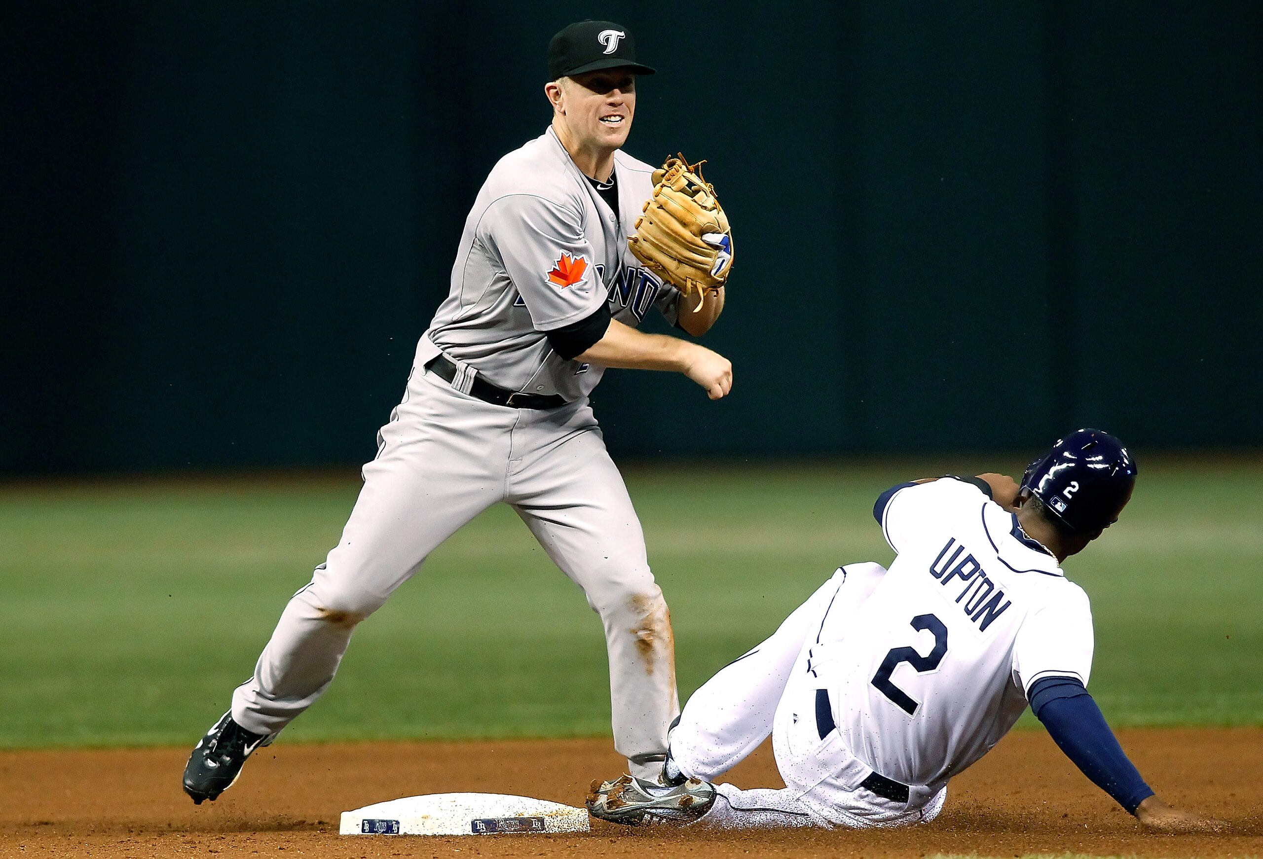 ST. PETERSBURG, FL - AUGUST 31:  Infielder Aaron Hill #2 of the Toronto Blue Jays turns a double play as outfielder B.J. Upton #2 of the Tampa Bay Rays tries to break it up during the game at Tropicana Field on August 31, 2010 in St. Petersburg, Florida.