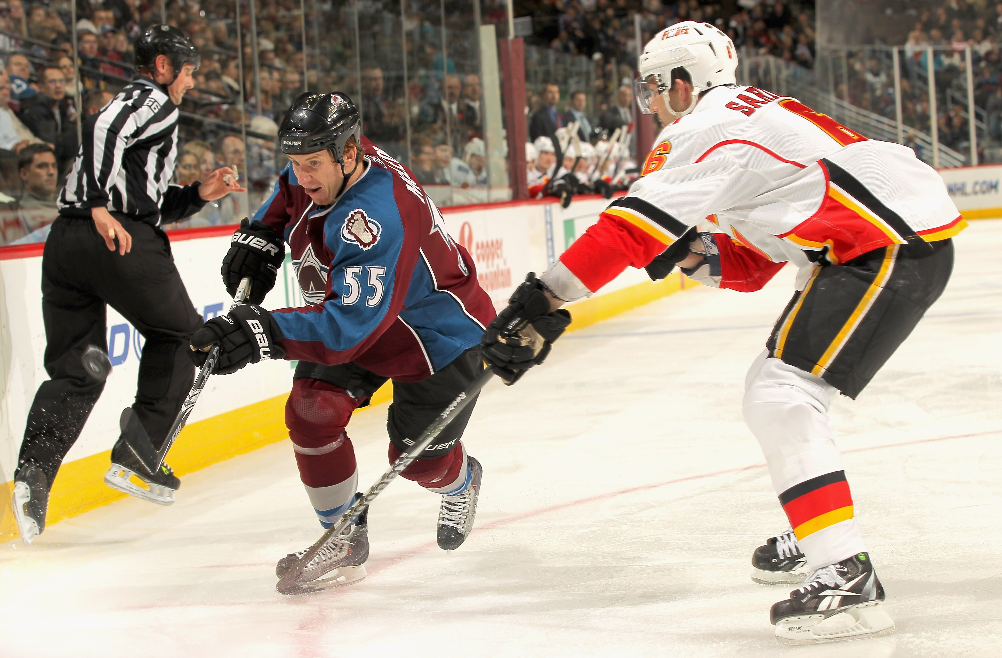 DENVER - NOVEMBER 09:  Cody McLeod #55 of the Colorado Avalanche controls the puck against Cory Sarich #6 of the Calgary Flames at the Pepsi Center on November 9, 2010 in Denver, Colorado. The Flames defeated the Avalanche 4-2.  (Photo by Doug Pensinger/G
