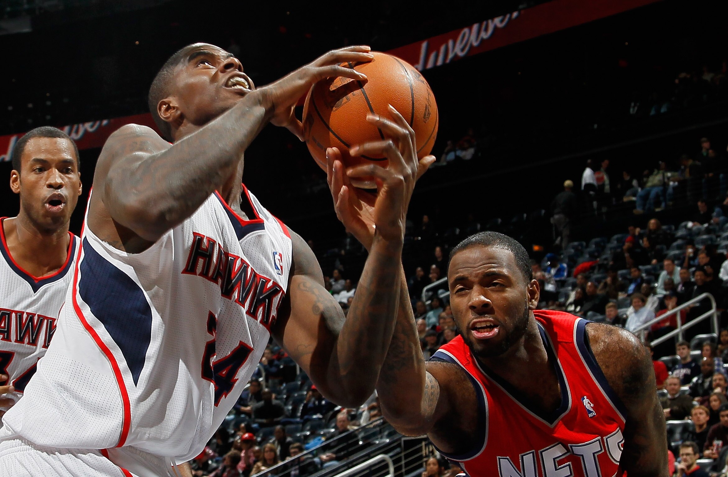 ATLANTA, GA - DECEMBER 07:  Marvin Williams #24 of the Atlanta Hawks is fouled by Damion James #10 of the New Jersey Nets at Philips Arena on December 7, 2010 in Atlanta, Georgia.  NOTE TO USER: User expressly acknowledges and agrees that, by downloading