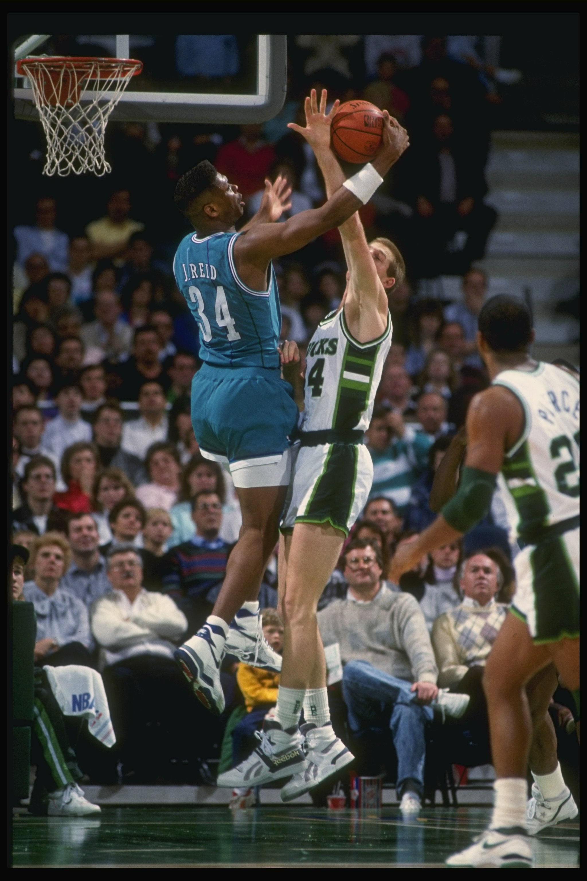 1989-1990:  Forward J. R. Reid of the Charlotte Hornets (left) battles for the ball with center Brad Lohaus of the Milwaukee Bucks during a game at the Bradley Center in Milwaukee, Wisconsin. Mandatory Credit: Allsport  /Allsport