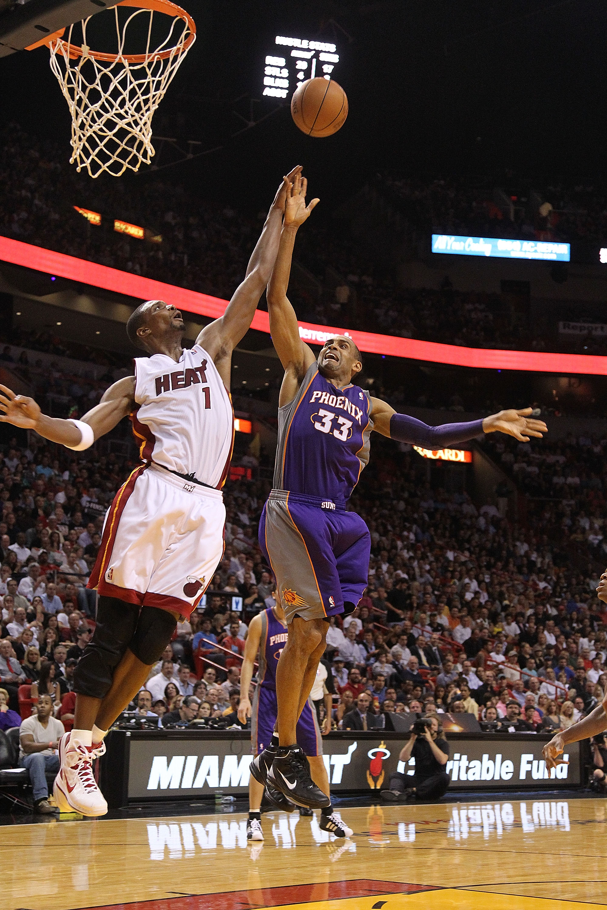 MIAMI - NOVEMBER 17:  Grant Hill #33 of the Phoenix Suns shoots a jumpshot  over Chris Bosh #1 during a game against the  Miami Heat at American Airlines Arena on November 17, 2010 in Miami, Florida. NOTE TO USER: User expressly acknowledges and agrees th
