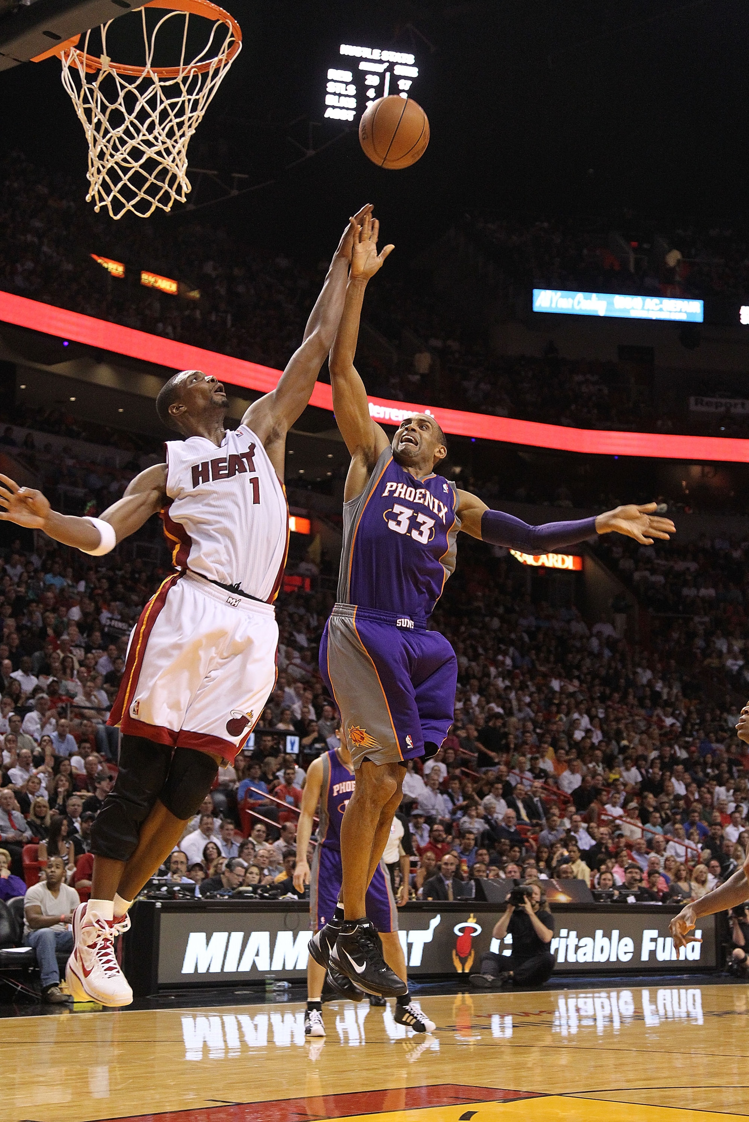 MIAMI - NOVEMBER 17:  Grant Hill #33 of the Phoenix Suns shoots a jumpshot  over Chris Bosh #1 during a game against the  Miami Heat at American Airlines Arena on November 17, 2010 in Miami, Florida. NOTE TO USER: User expressly acknowledges and agrees th
