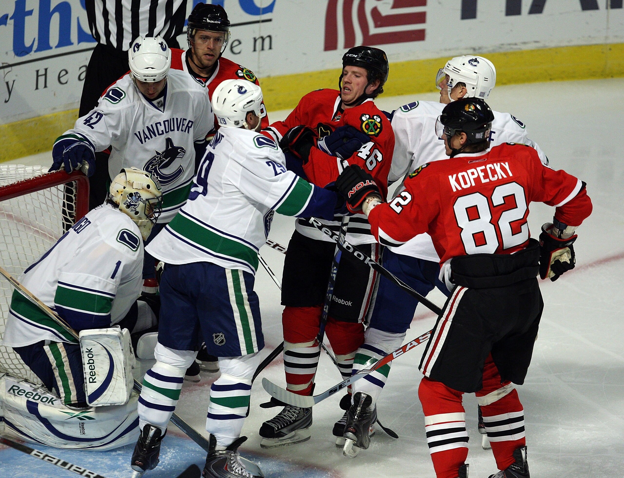 CHICAGO - OCTOBER 21: Colin Fraser #46 of the Chicago Blackhawks mixes it up with Aaron Rome #29 of the Vancouver Canucks in front of the net at the United Center on October 14, 2009 in Chicago, Illinois. The Canucks defeated the Blackhawks 3-2. (Photo by