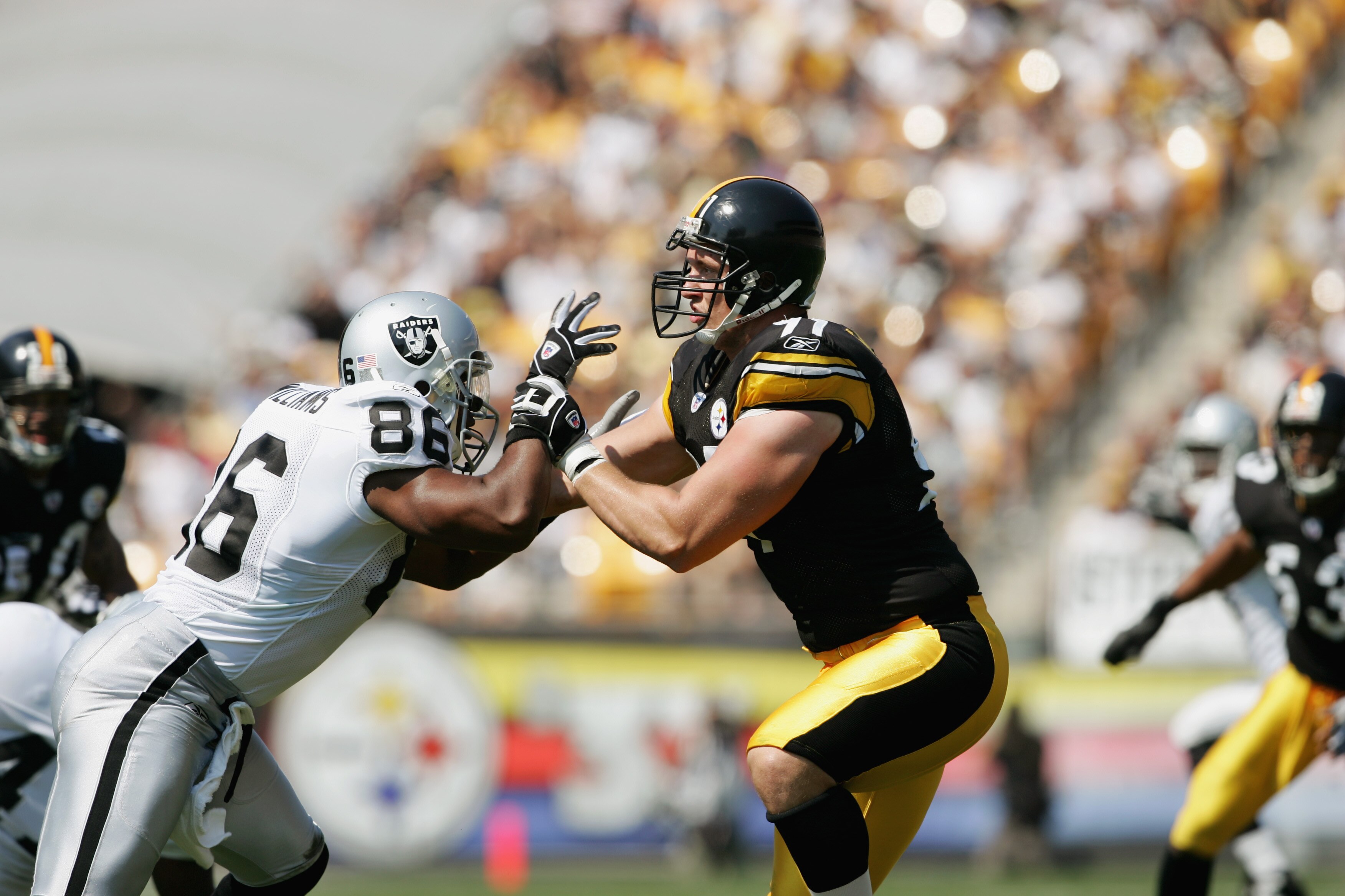 PITTSBURGH - SEPTEMBER 12:  Tight end Roland Williams #86 of the Oakland Raiders tries to get past defensive end Aaron Smith #91 of the Pittsburgh Steelers during the game at Heinz Field on September 12, 2004 in Pittsburgh, Pennsylvania. The Steelers defe