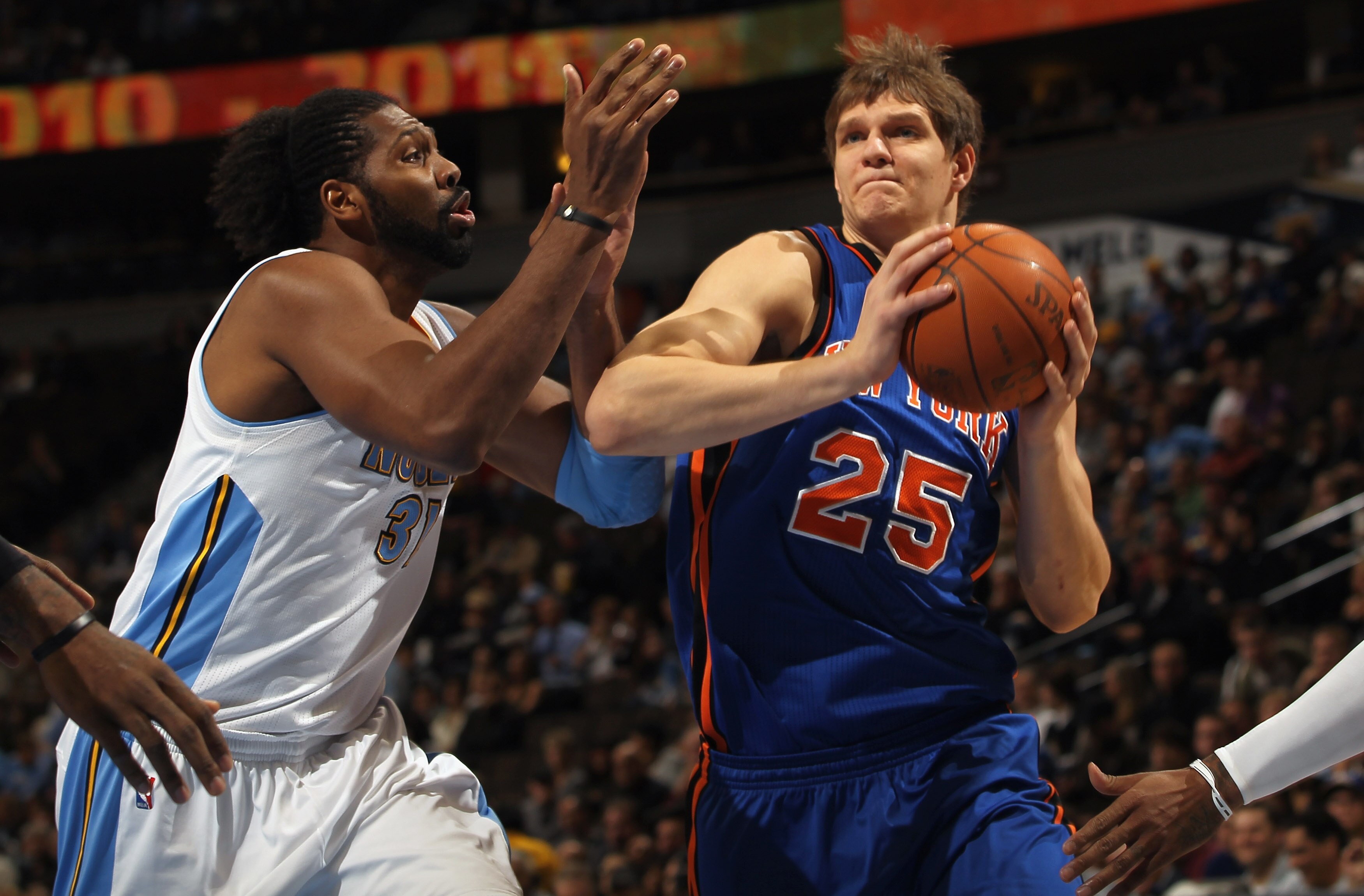 DENVER - NOVEMBER 16:  Timofey Mozgov #25 of the New York Knicks drives past Nene #31 of the Denver Nuggets at the Pepsi Center on November 16, 2010 in Denver, Colorado. NOTE TO USER: User expressly acknowledges and agrees that, by downloading and/or usin