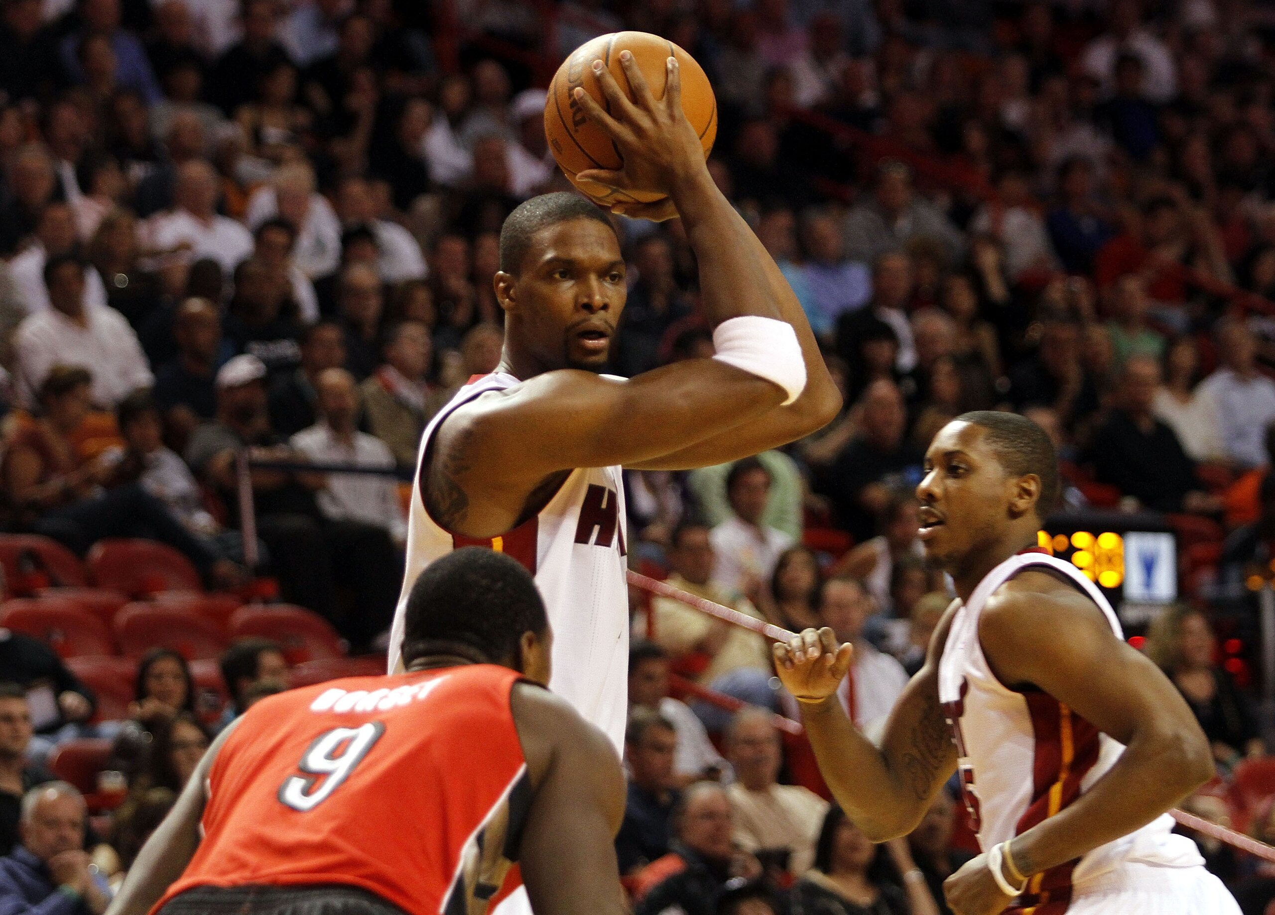 MIAMI - NOVEMBER 13:  Forward Chris Bosh #1 of the Miami Heat drives against Joey Dorsey #9 of the Toronto Raptors at American Airlines Arena on November 13, 2010 in Miami, Florida. NOTE TO USER: User expressly acknowledges and agrees that, by downloading