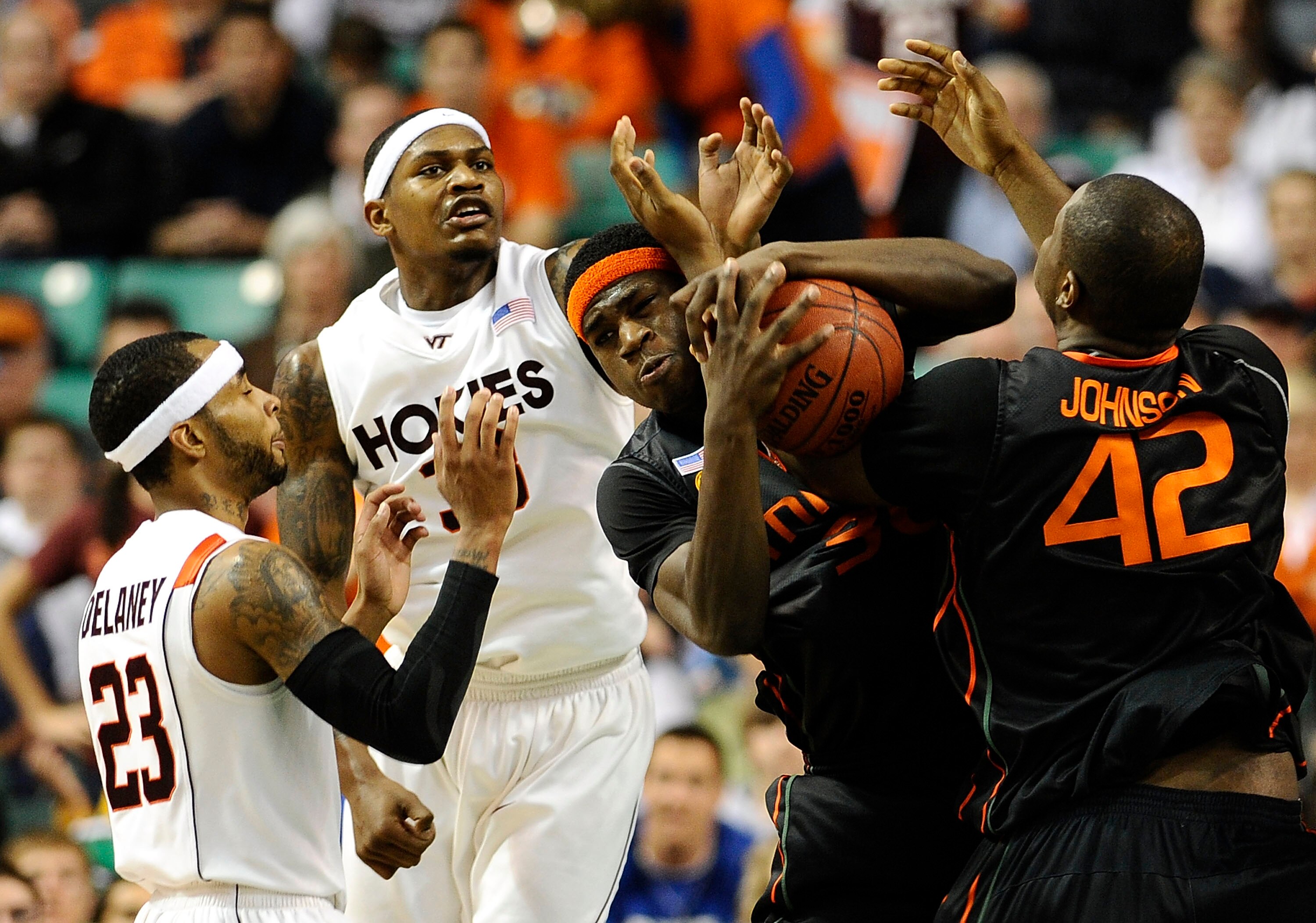 GREENSBORO, NC - MARCH 12:  Malcolm Delaney #23 and JT Thompson #33 of the Virginia Tech Hokies fight for a loose ball with Adrian Thomas #30 and Reggie Johnson #42  of the University of Miami Hurricanes in their quarterfinal game in the 2010 ACC Men's Ba
