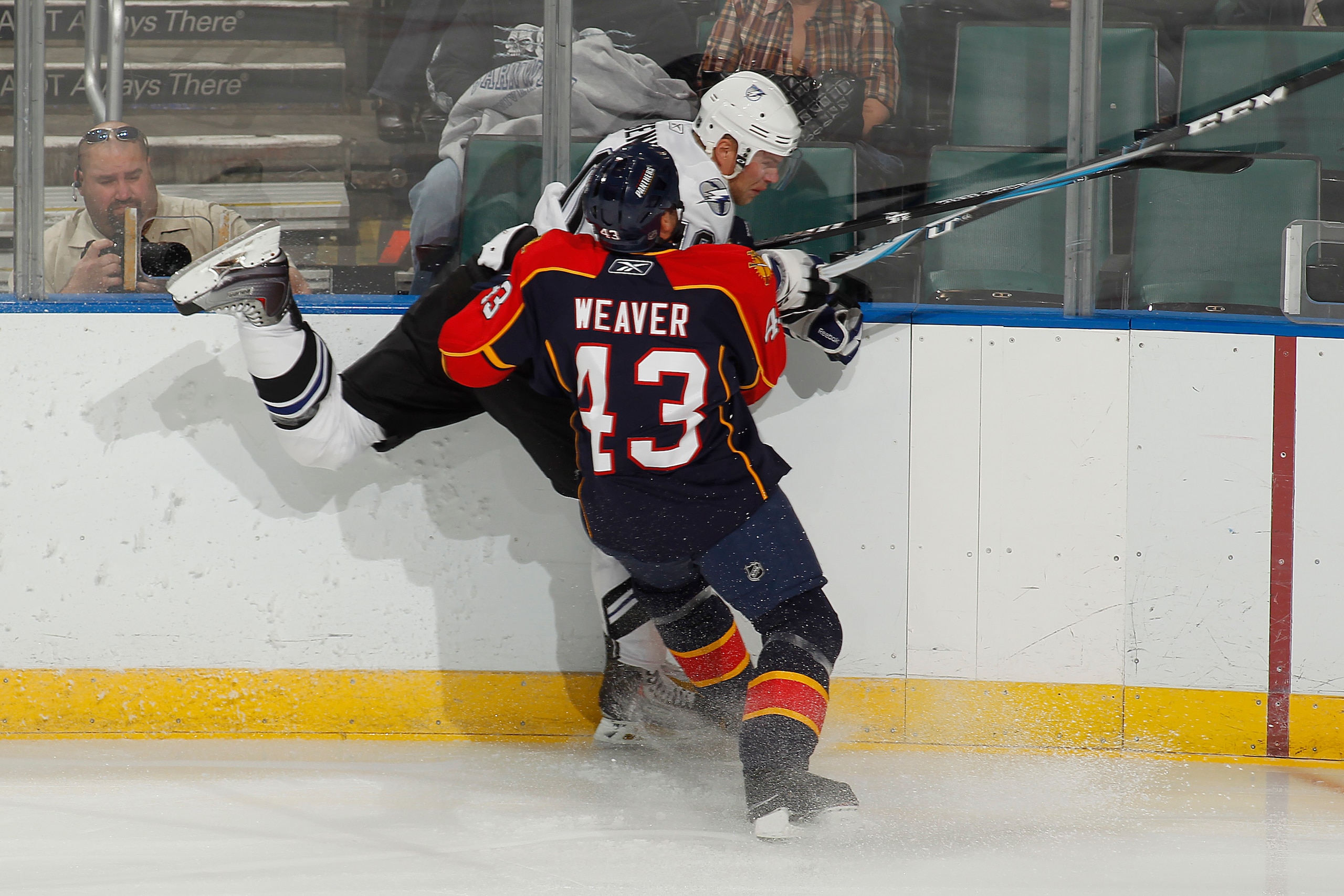 SUNRISE, FL - OCTOBER 1: Sean Bergenheim #10 of the Tampa Bay Lightning is checked into the boards by Mike Weaver #43 of the Florida Panthers during a preseason game on October 1, 2010 at the BankAtlantic Center in Sunrise, Florida. (Photo by Joel Auerbac
