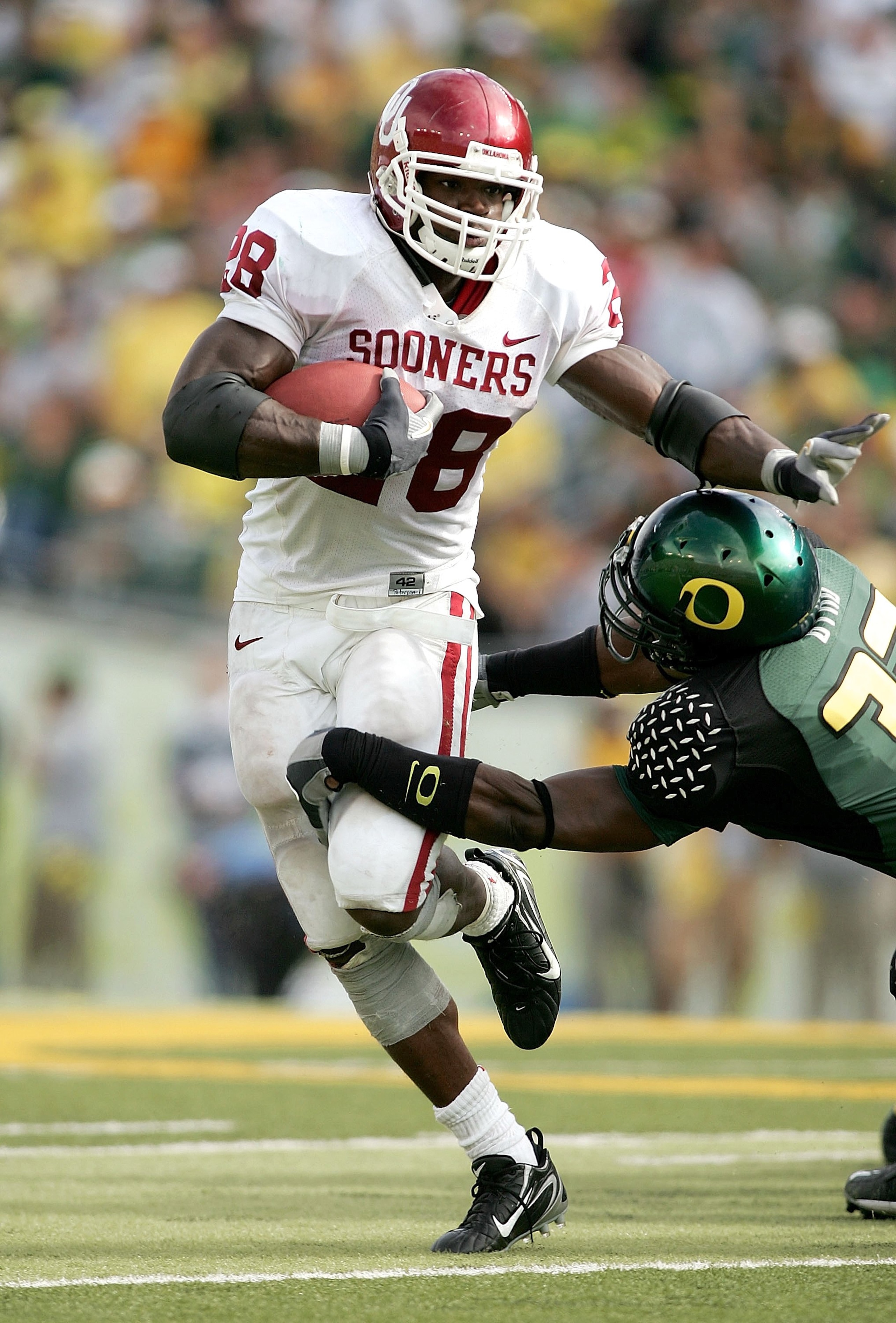 EUGENE, OR - SEPTEMBER 16: Adrian Peterson #28 of the Oklahoma Sooners runs against Jarius Byrd #32 of the Oregon Ducks on September 16, 2006 at Autzen Stadium in Eugene, Oregon. (Photo by Jonathan Ferrey/Getty Images)