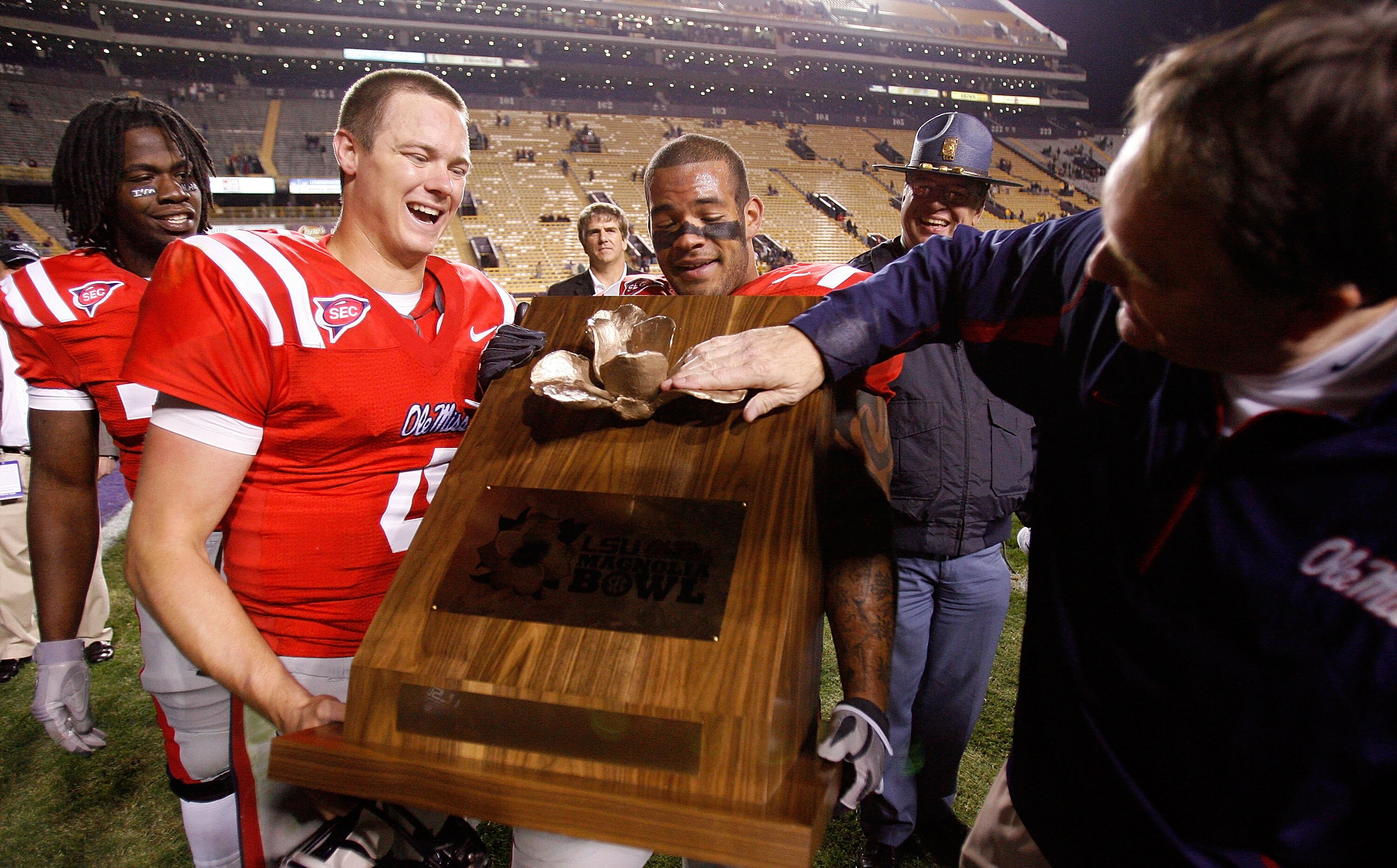 BATON ROUGE, LA - NOVEMBER 22:  Quarterback Jevan Snead #4, Patrick Trahan #7 and head coach Houston Nutt of the Ole Miss Rebels celebrate with the 'Magnolia Bowl' trophy after defeating the Louisiana State University Tigers 31-13 on November 22, 2008 at 