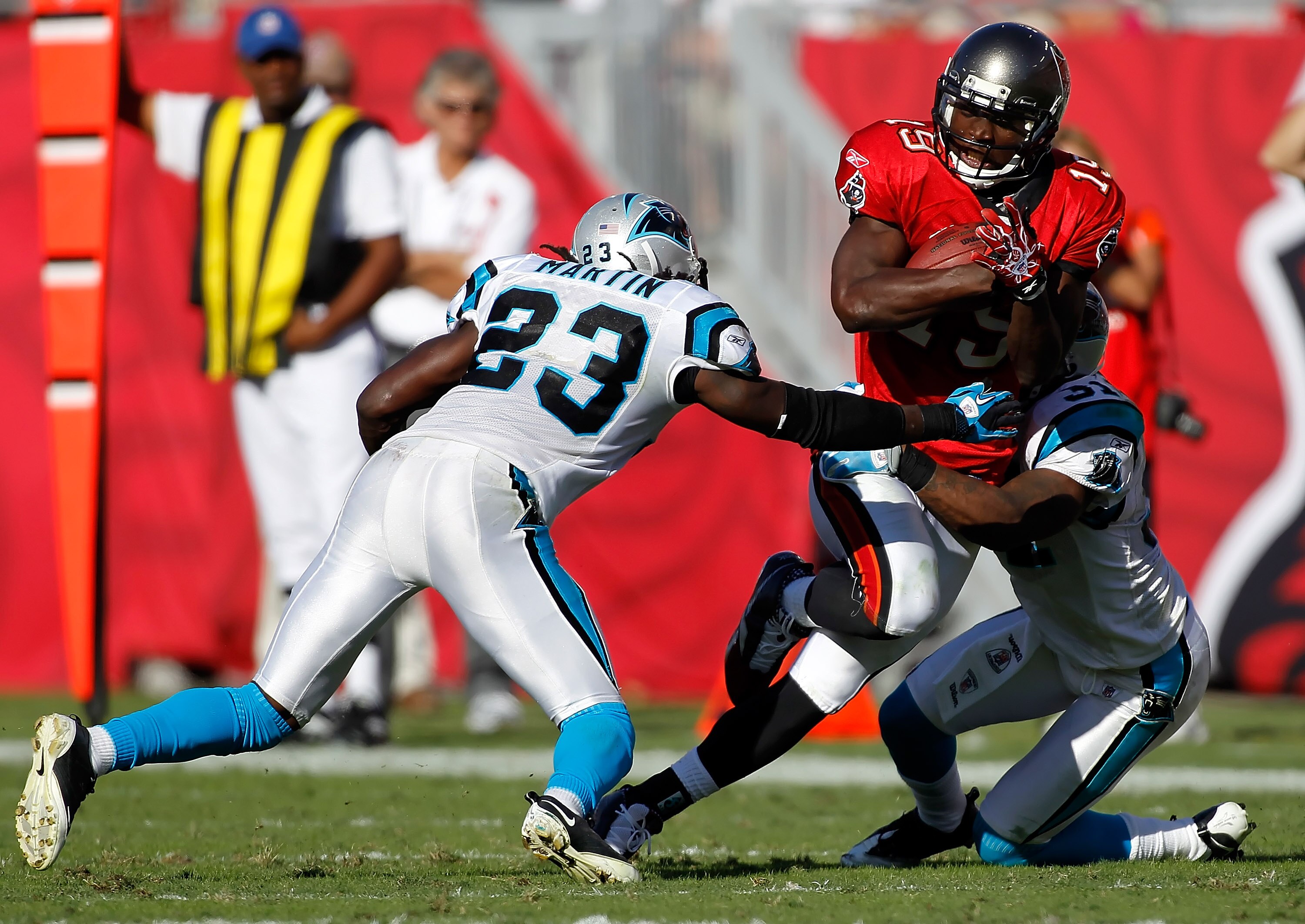 TAMPA, FL - NOVEMBER 14:  Receiver Mike Williams #19 of the Tampa Bay Buccaneers is tackled by defenders Sherrod Martin #23 and Richard Marshall #31 of the Carolina Panthers during the game at Raymond James Stadium on November 14, 2010 in Tampa, Florida.