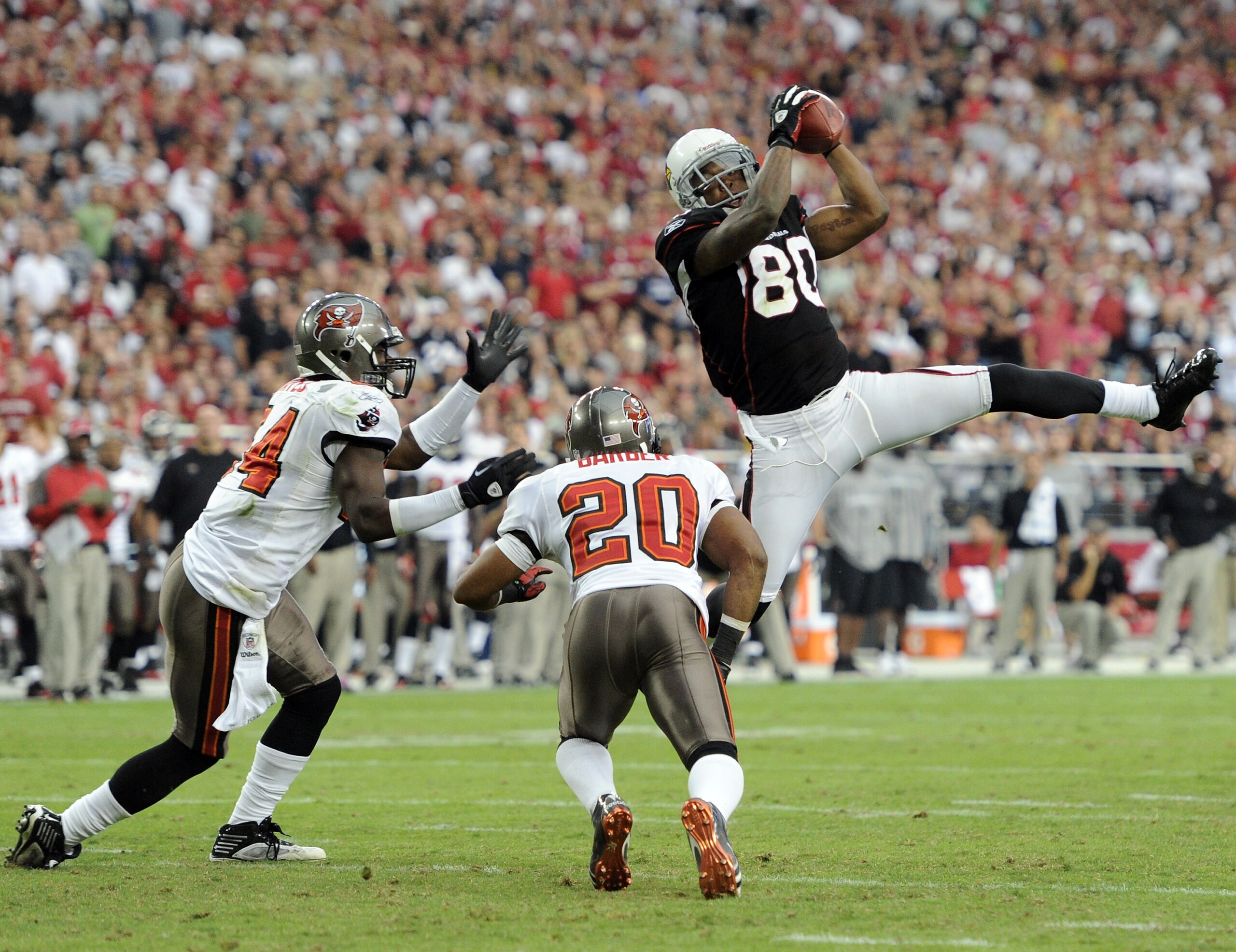 GLENDALE, AZ - OCTOBER 31: Early Doucet #80 of the Arizona Cardinals makes a catch in front of Ronde Barber #20 and Geno Hayes #54 of the Tampa Bay Buccaneers during the fourth quarter at University of Phoenix Stadium on October 31, 2010 in Glendale, Ari GLENDALE, AZ - OCTOBER 31: Early Doucet #80 of the Arizona Cardinals makes a catch in front of Ronde Barber #20 and Geno Hayes #54 of the Tampa Bay Buccaneers during the fourth quarter at University of Phoenix Stadium on October 31, 2010 in Glendale, Ari