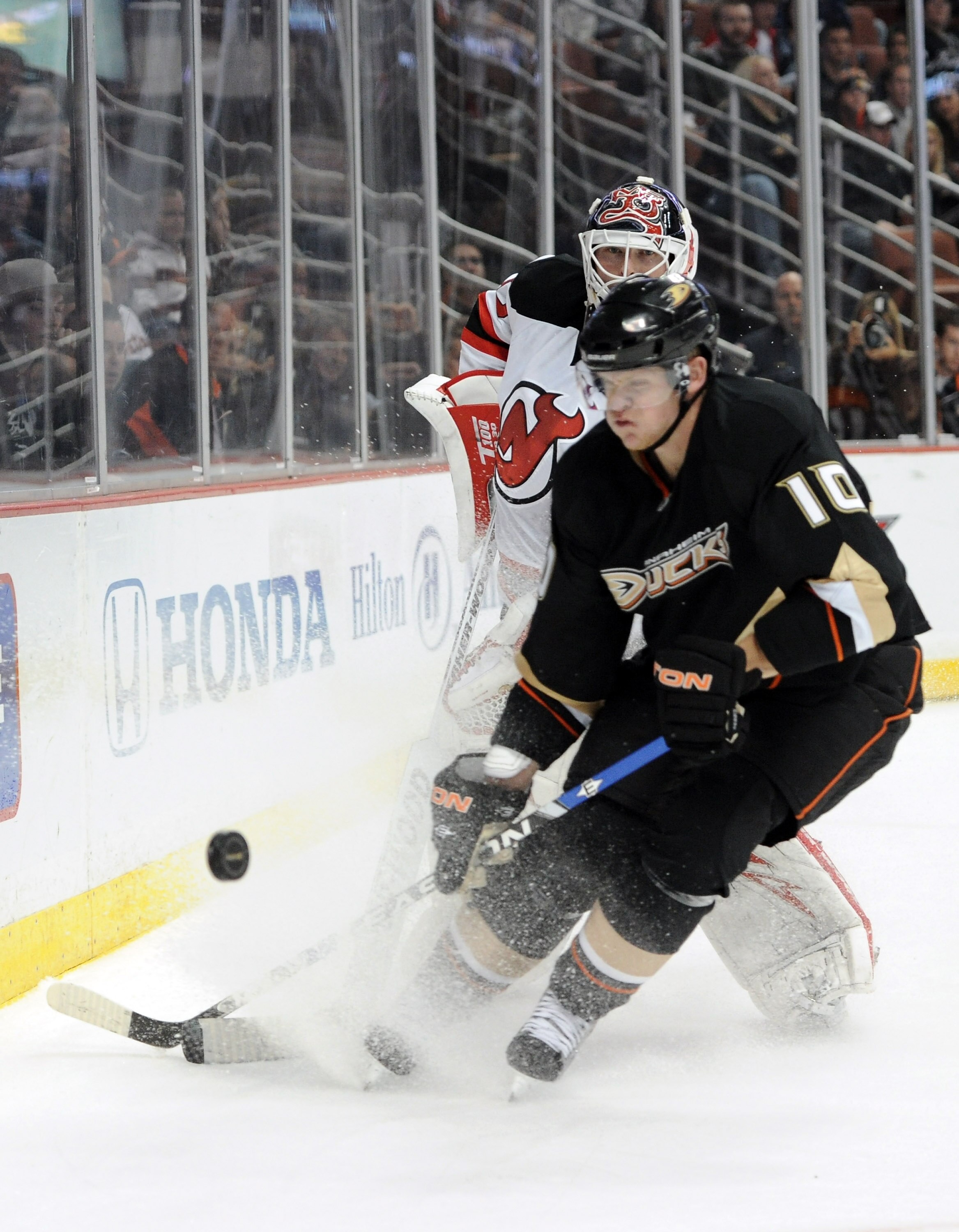 ANAHEIM, CA - OCTOBER 29:  Martin Brodeur #30 of the New Jersey Devils clears the puck in front of Corey Perry #10 of the Anaheim Ducks at the Honda Center on October 29, 2010 in Anaheim, California.  (Photo by Harry How/Getty Images)