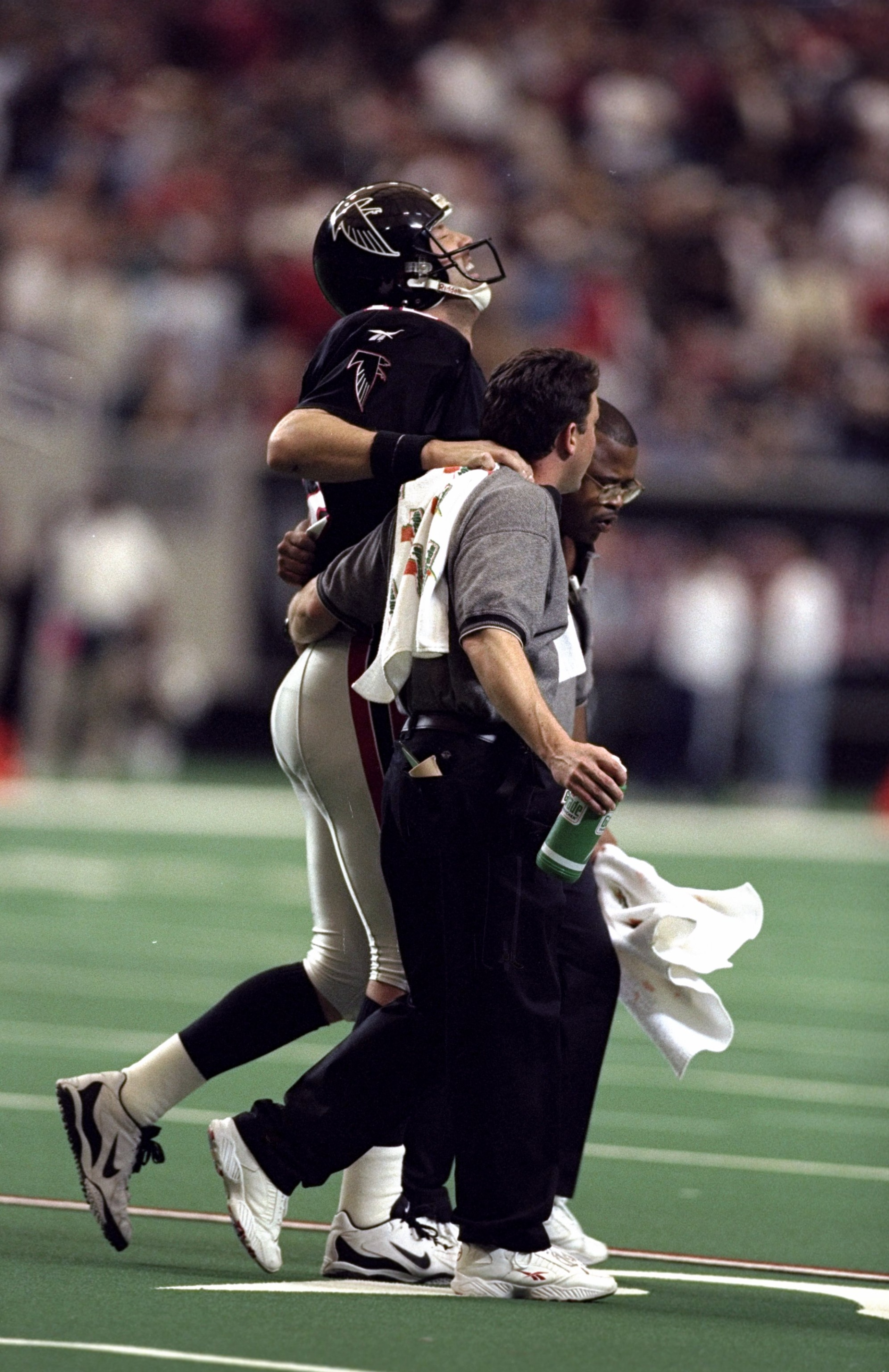 27 Dec 1998: Chris Chandler #12 of the Atlanta Falcons is helped off the field during the game against the Miami Dolphins at the Georgia Dome in Atlanta, Georgia. The Falcons defeated the Dolphins 38-16.