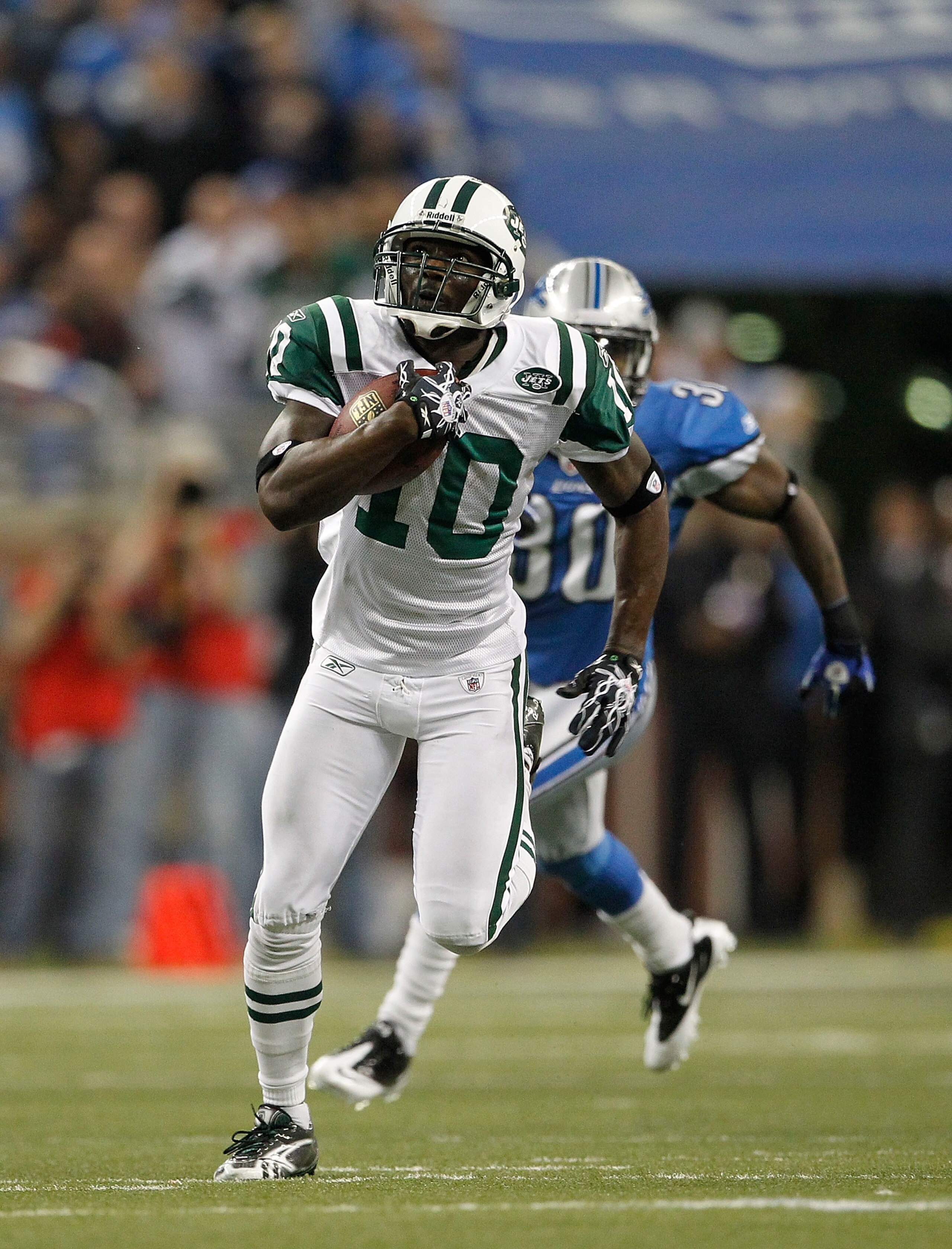 DETROIT - NOVEMBER 07:  Santonio Holmes #10 of the New York Jets catches a 54 yard pass in overtime and is tackled by Landon Johnson #54 of the Detroit Lions during the overtime period at Ford Field on November 7, 2010 in Detroit, Michigan. The Jets defea