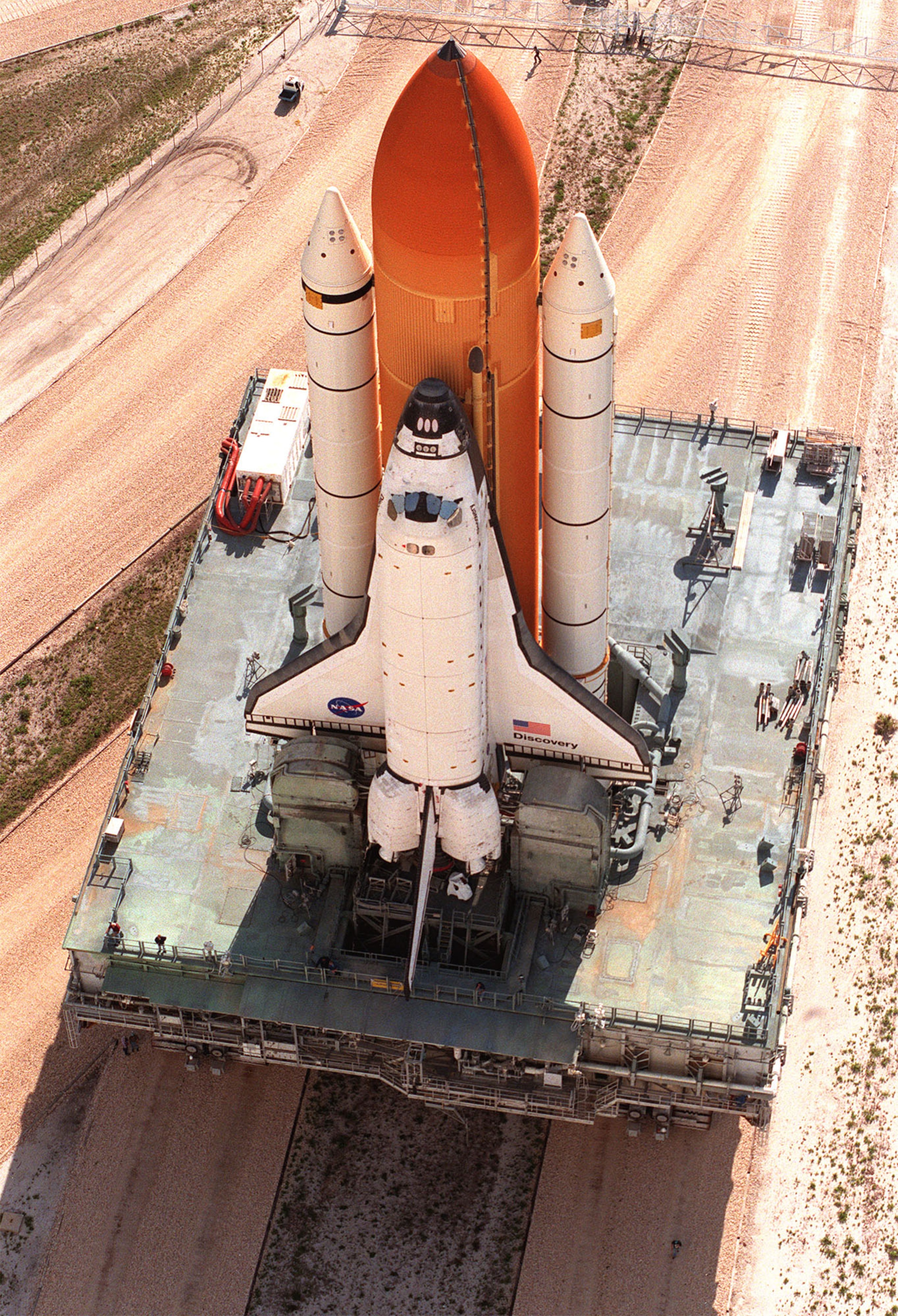 At a juncture in the crawlerway, a crawler transporter moves Space Shuttle Discovery back to the Vehicle Assembly Building from Pad 39B for repair of damage to the external tank foam insulation caused by hail May 16, 1999. The work is expected to take two At a juncture in the crawlerway, a crawler transporter moves Space Shuttle Discovery back to the Vehicle Assembly Building from Pad 39B for repair of damage to the external tank foam insulation caused by hail May 16, 1999. The work is expected to take two