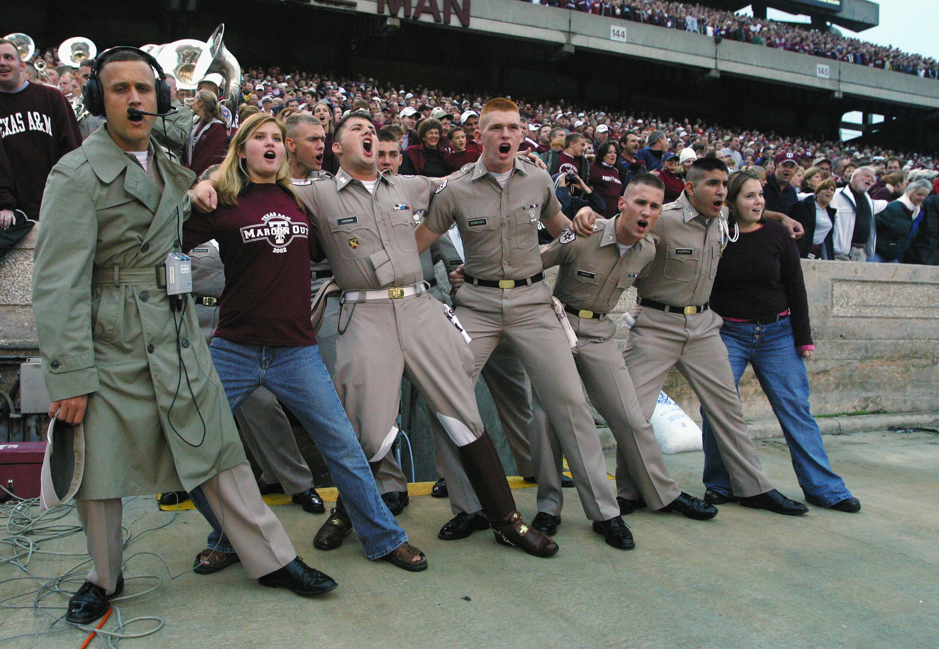 COLLEGE STATION, TX - OCTOBER 26:  Texas A&M Aggies cadets and their dates sing a school fight song and do a traditional arm in arm swaying in the game on October 26, 2002 versus the Nebraska Cornhuskers at Kyle Field at College Station, Texas. Nebraska w