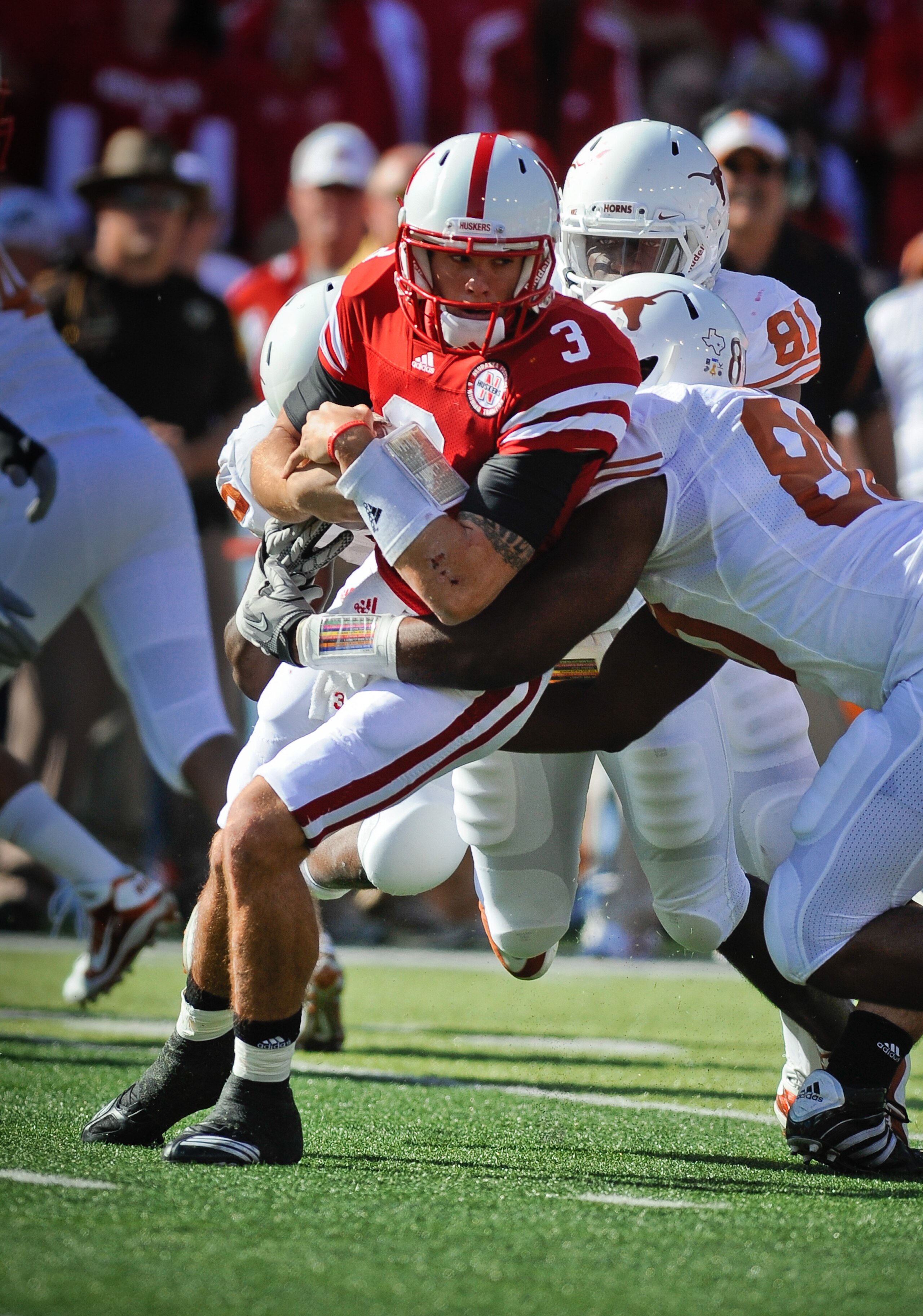 LINCOLN, NE - OCTOBER 16: Quarterback Taylor Martinez #3 of the Nebraska Cornhuskers tries to slip the grasp of defensive end Alex Okafor #80 of the Texas Longhorns during first half action of their game at Memorial Stadium on October 16, 2010 in Lincoln,