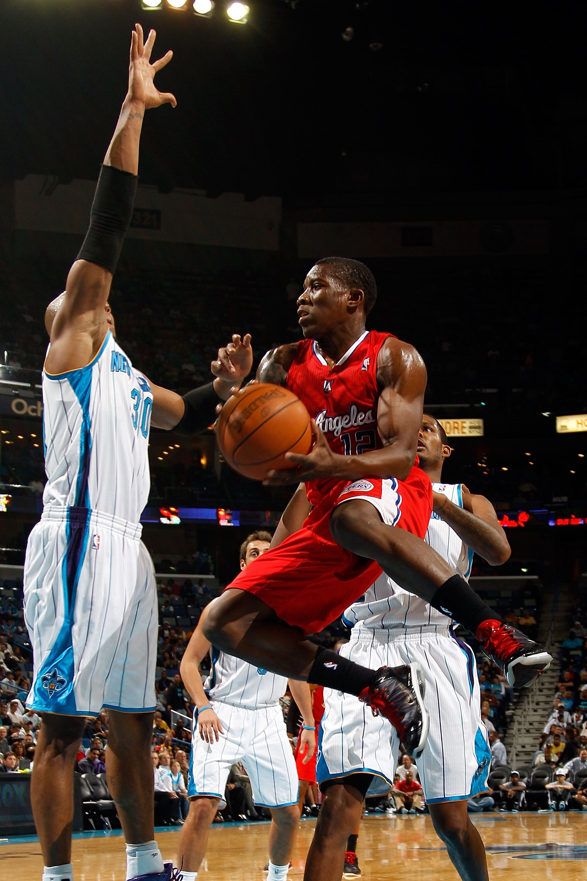 NEW ORLEANS - NOVEMBER 09:  Eric Bledsoe #12 of the Los Angeles Clippers passes the ball around David West #30 of the New Orleans Hornets at the New Orleans Arena on November 9, 2010 in New Orleans, Louisiana. The Hornets defeated the Clippers 101-82.   N