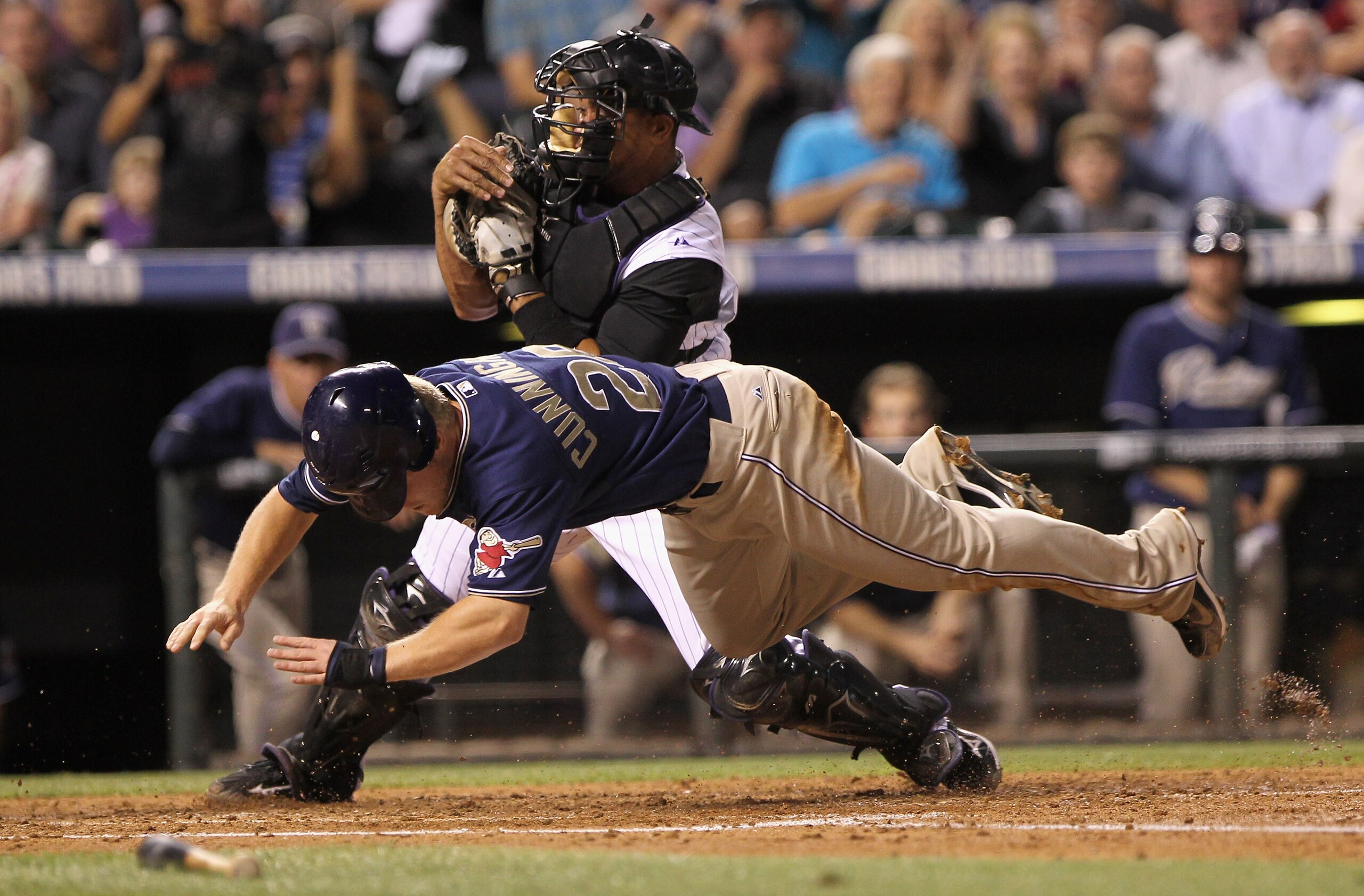DENVER - SEPTEMBER 13:  Aaron Cunningham #28 of the San Diego Padres is tagged out at home by catcher Miguel Olivo #21 of the Colorado Rockies for the final out of the third inning as Cunningham tried to score on an Adrian Gonzalez base hit at Coors Field