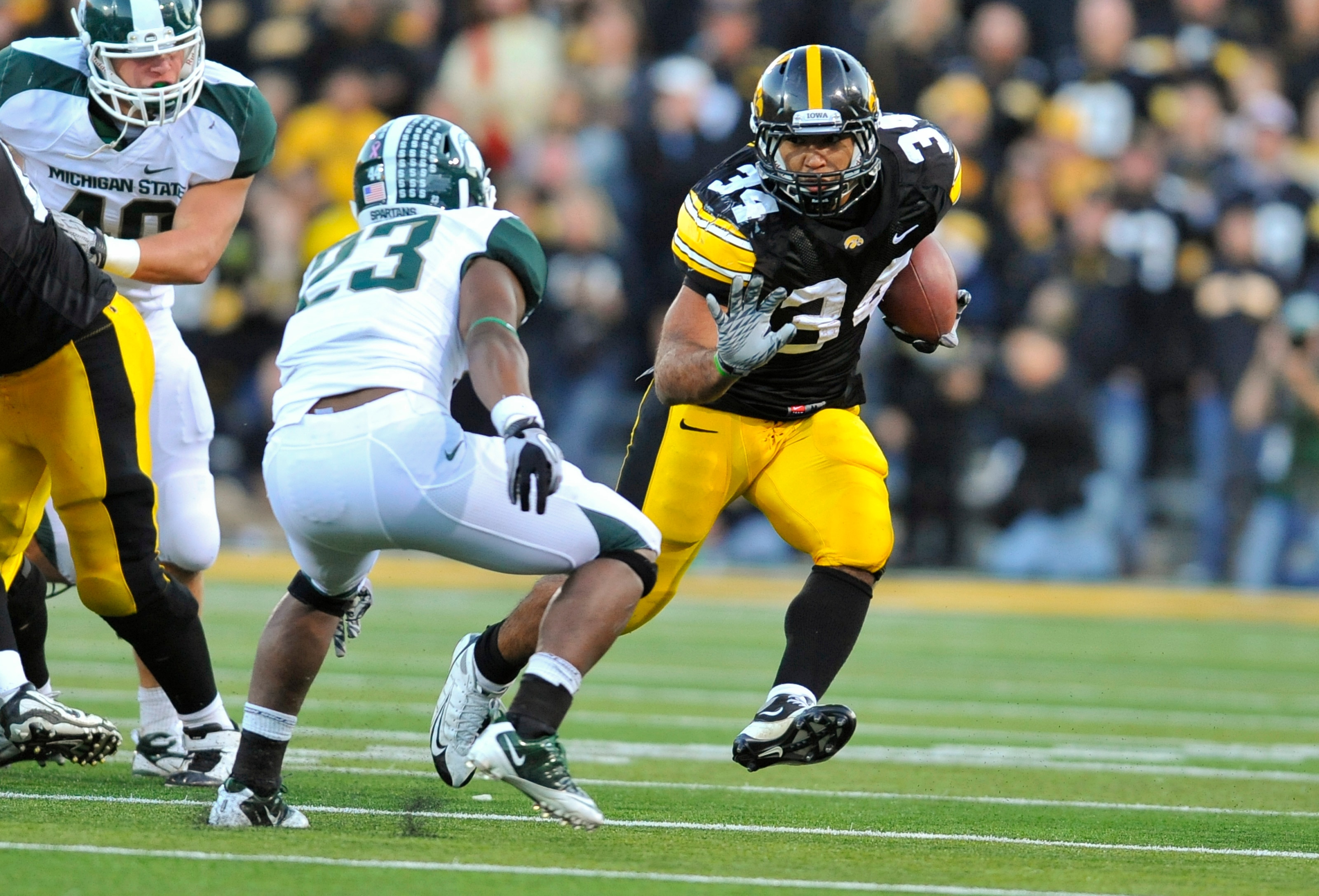 IOWA CITY, IA - OCTOBER 30- Running back Marcus Coker #34 of the University of Iowa Hawkeyes runs past safety Jairus Jones #23 of the Michigan State Spartans during the second half of play at Kinnick Stadium on October 30, 2010 in Iowa City, Iowa. Iowa wo