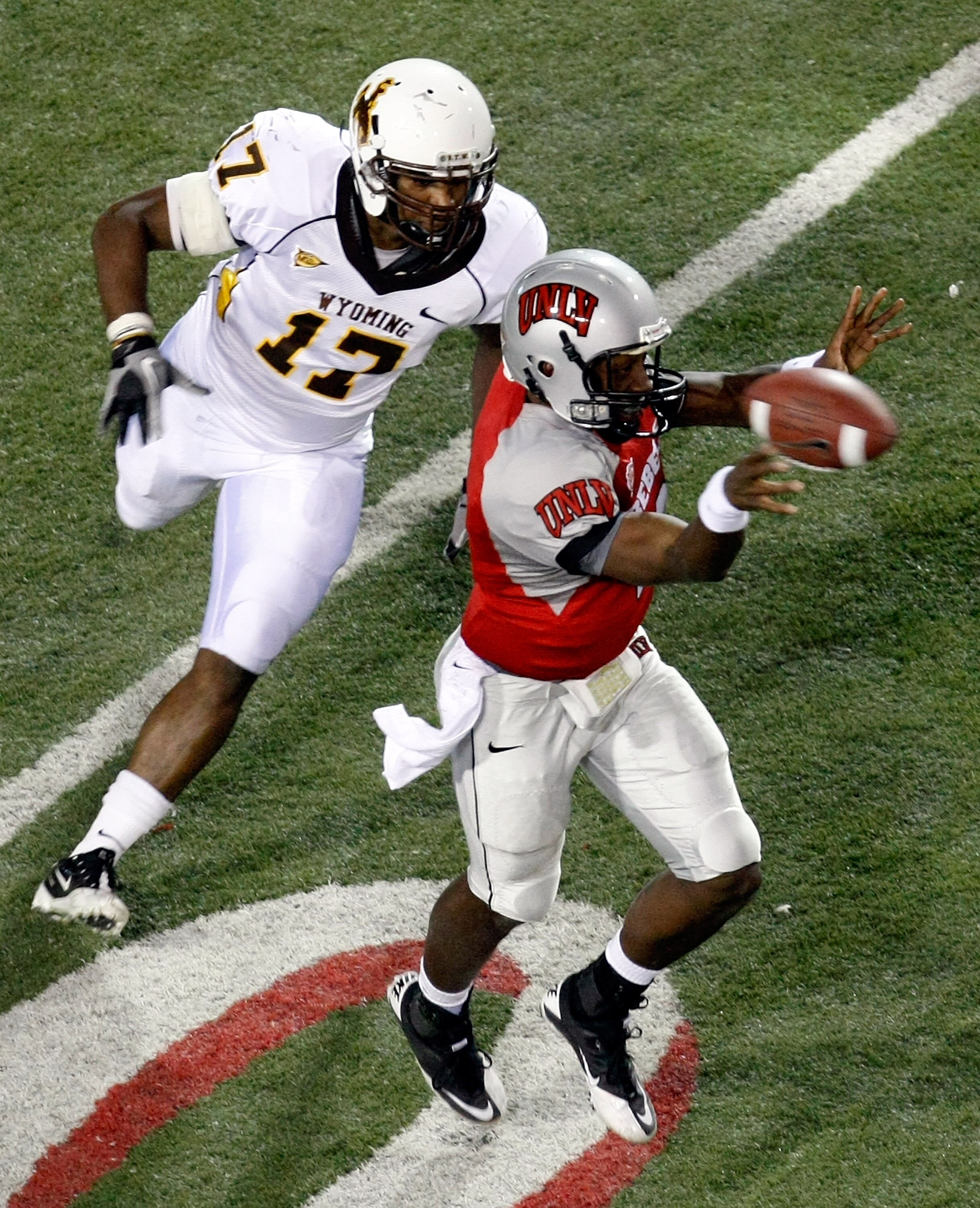 LAS VEGAS - NOVEMBER 13:  Quarterback Omar Clayton #2 of the UNLV Rebels throws under pressure from Keith Lewis #17 of the Wyoming Cowboys during their game at Sam Boyd Stadium November 13, 2010 in Las Vegas, Nevada. UNLV won 42-16.  (Photo by Ethan Mille
