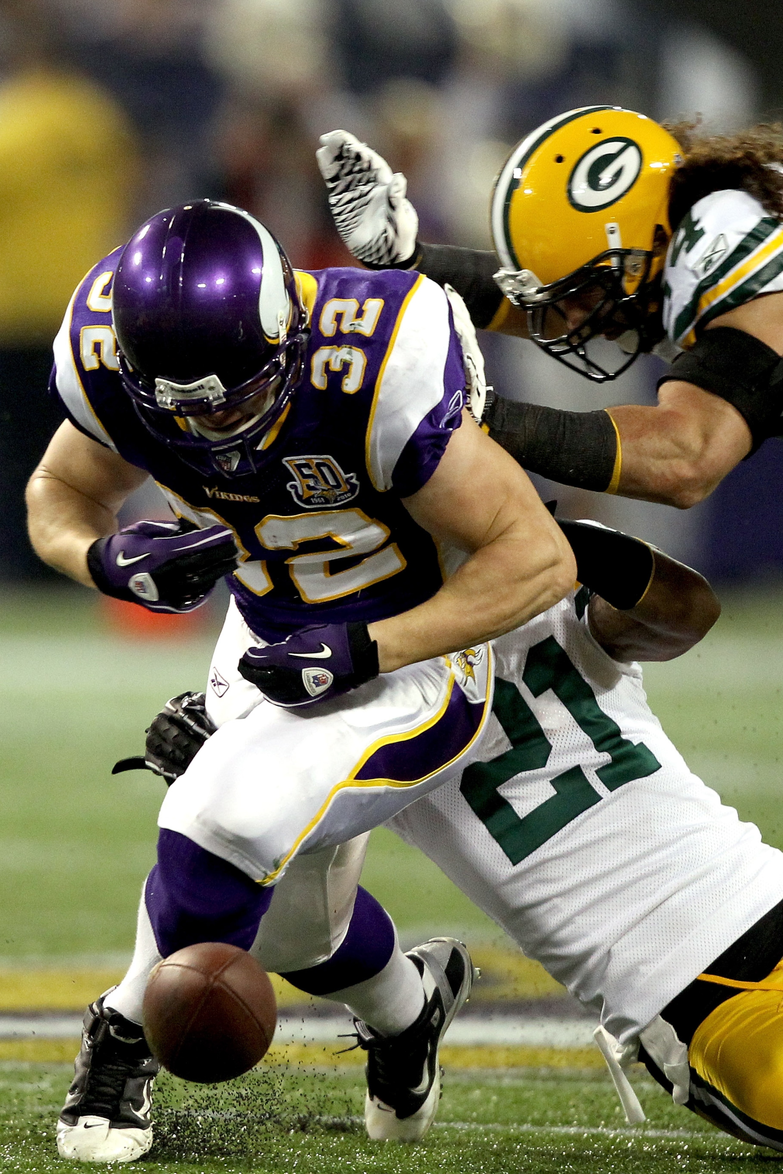 MINNEAPOLIS - NOVEMBER 21:  Toby Gerhart #32 of the Minnesota Vikings has the ball jarred loose by Charles Woodson #21 and Brandon Chillar #54 of the Green Bay Packers at the Hubert H. Humphrey Metrodome on November 21, 2010 in Minneapolis, Minnesota.  (P