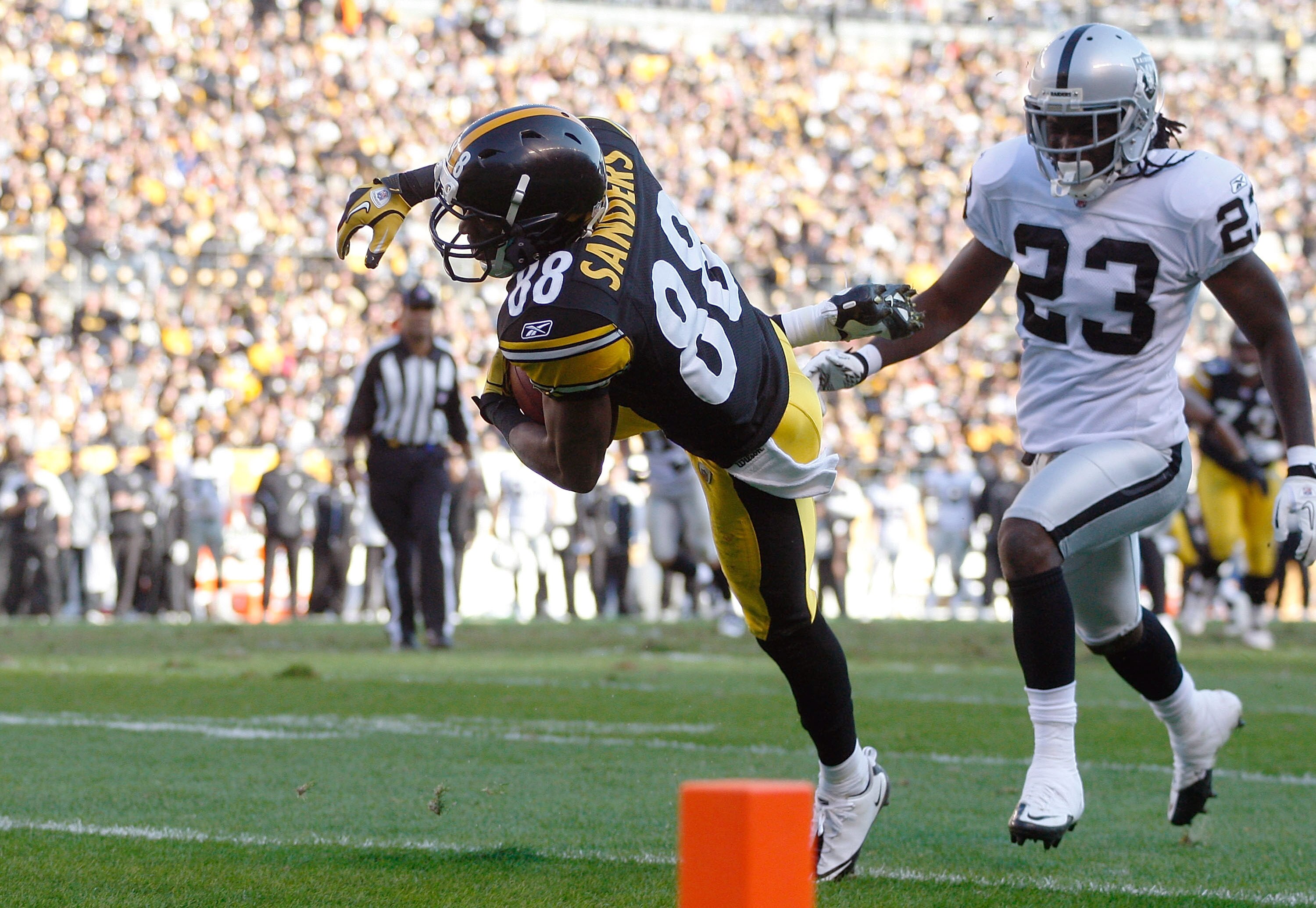PITTSBURGH - NOVEMBER 21:  Emmanuel Sanders #88 of the Pittsburgh Steelers catches a pass before rolling into the endzone for a touchdown in front of Jeremy Ware #23 of the Oakland Raiders during the game against on November 21, 2010 at Heinz Field in Pit
