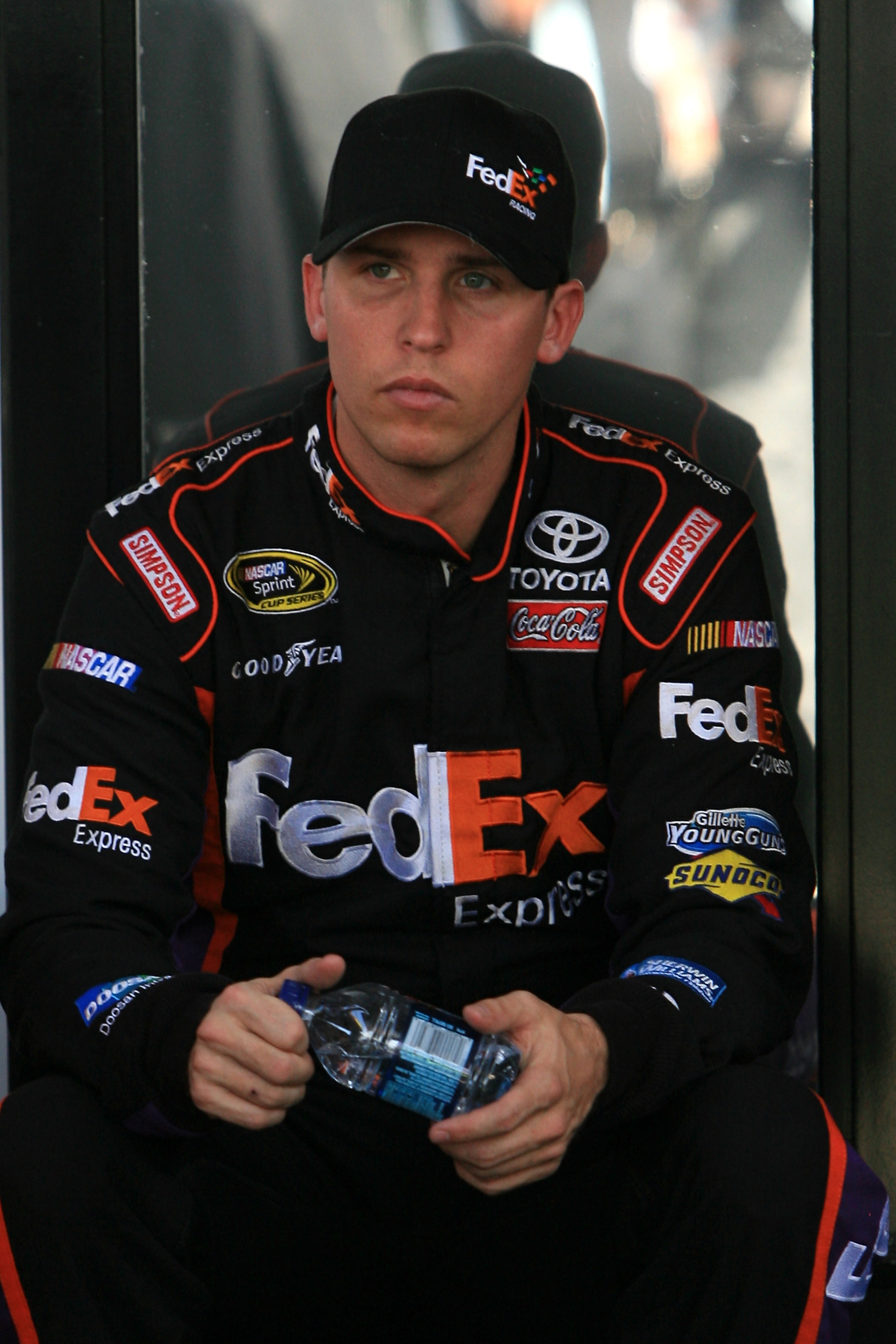 HOMESTEAD, FL - NOVEMBER 19:  Denny Hamlin, driver of the #11 FedEx Toyota, sits by his team hauler in the garage area during practice for the NASCAR Sprint Cup Series Ford 400 at Homestead-Miami Speedway on November 19, 2010 in Homestead, Florida.  (Phot