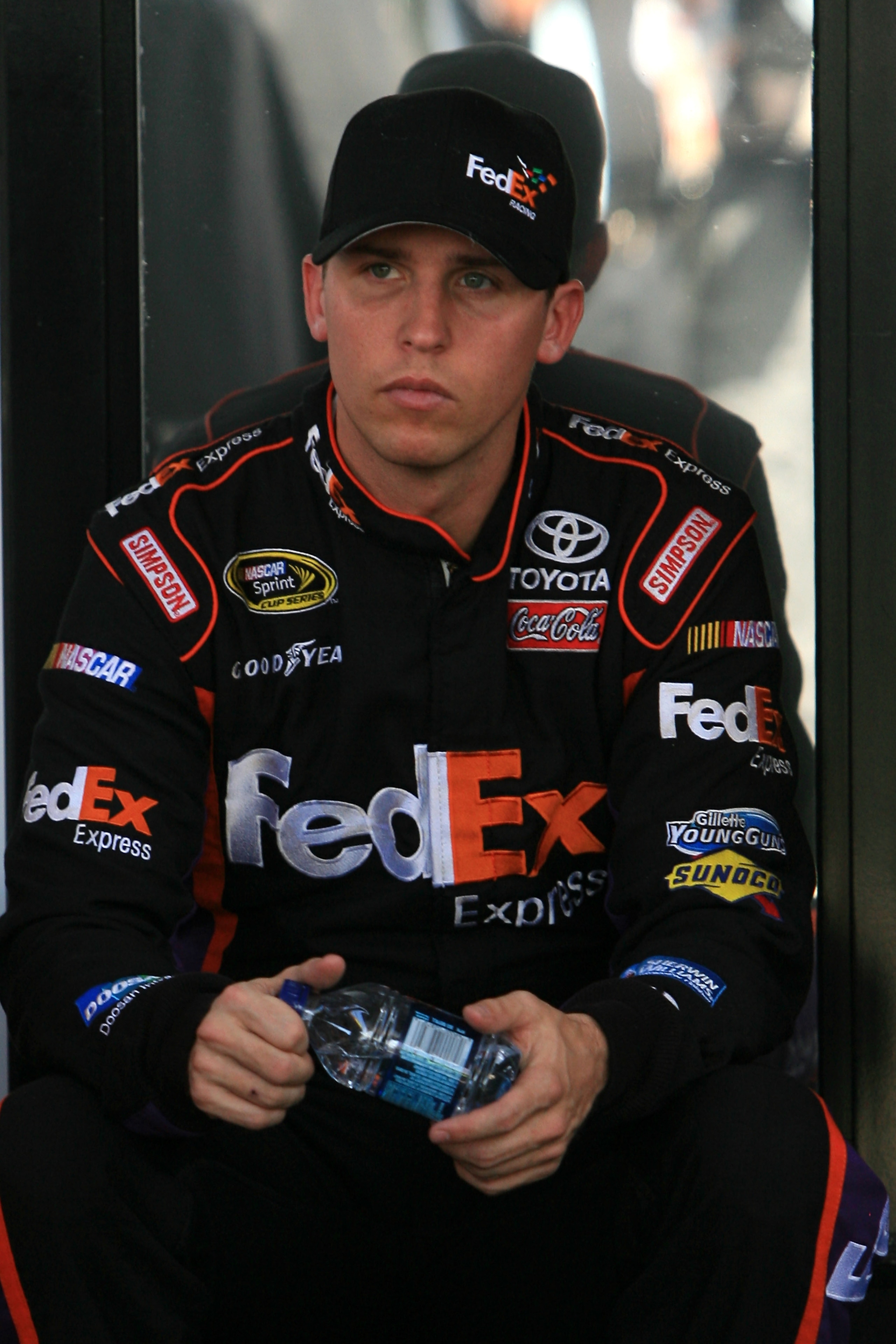 HOMESTEAD, FL - NOVEMBER 19:  Denny Hamlin, driver of the #11 FedEx Toyota, sits by his team hauler in the garage area during practice for the NASCAR Sprint Cup Series Ford 400 at Homestead-Miami Speedway on November 19, 2010 in Homestead, Florida.  (Phot