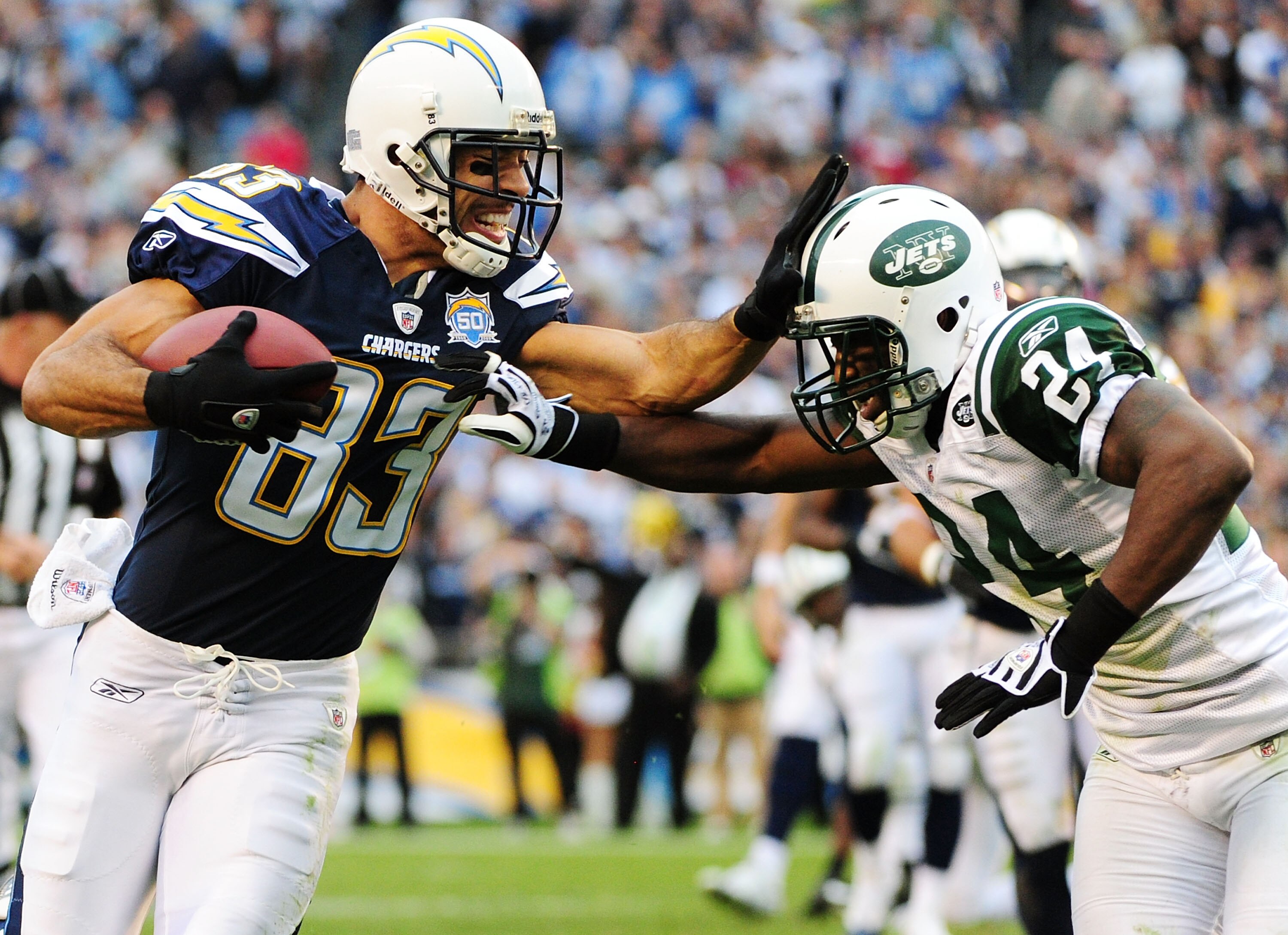 SAN DIEGO - JANUARY 17:  Wide receiver Vincent Jackson #83 of the San Diego Chargers stiff-arms cornerback Darrelle Revis #24 of the New York Jets during  AFC Divisional Playoff Game at Qualcomm Stadium on January 17, 2010 in San Diego, California.  (Phot