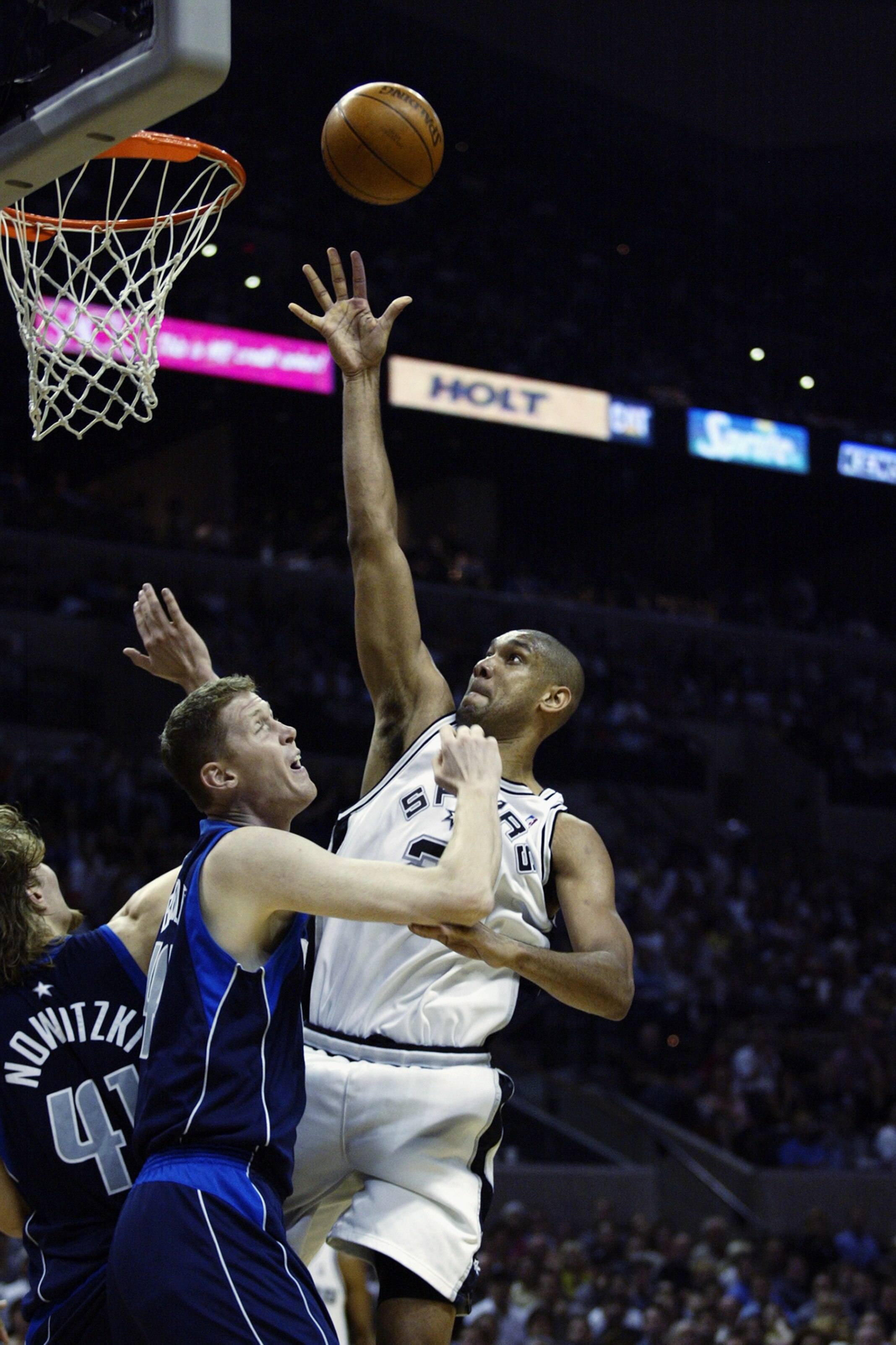 SAN ANTONIO - MAY 19:  Tim Duncan #21 of the San Antonio Spurs shoots over Shawn Bradley #45 and Dirk Nowitzki #41 of the Dallas Mavericks in Game one of the Western Conference Finals during the 2003 NBA Playoffs at SBC Center on May 19, 2003 in San Anton