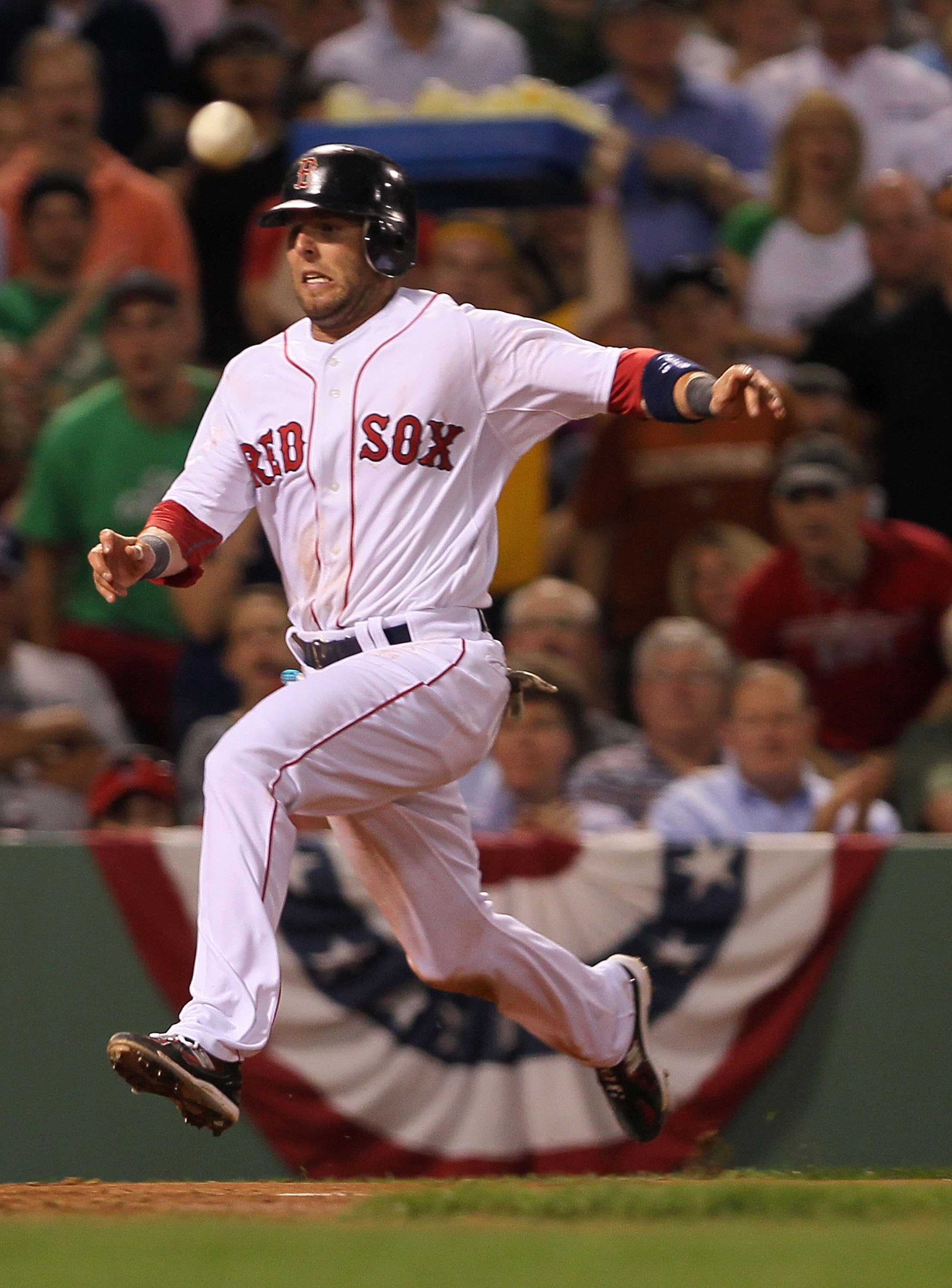 BOSTON - APRIL 07:  Dustin Pedroia #15 of the Boston Red Sox scores a run as Jorge Posada #20 of the New York Yankees fields a late throw at Fenway Park on April 7, 2010 in Boston, Massachusetts. (Photo by Jim Rogash/Getty Images)