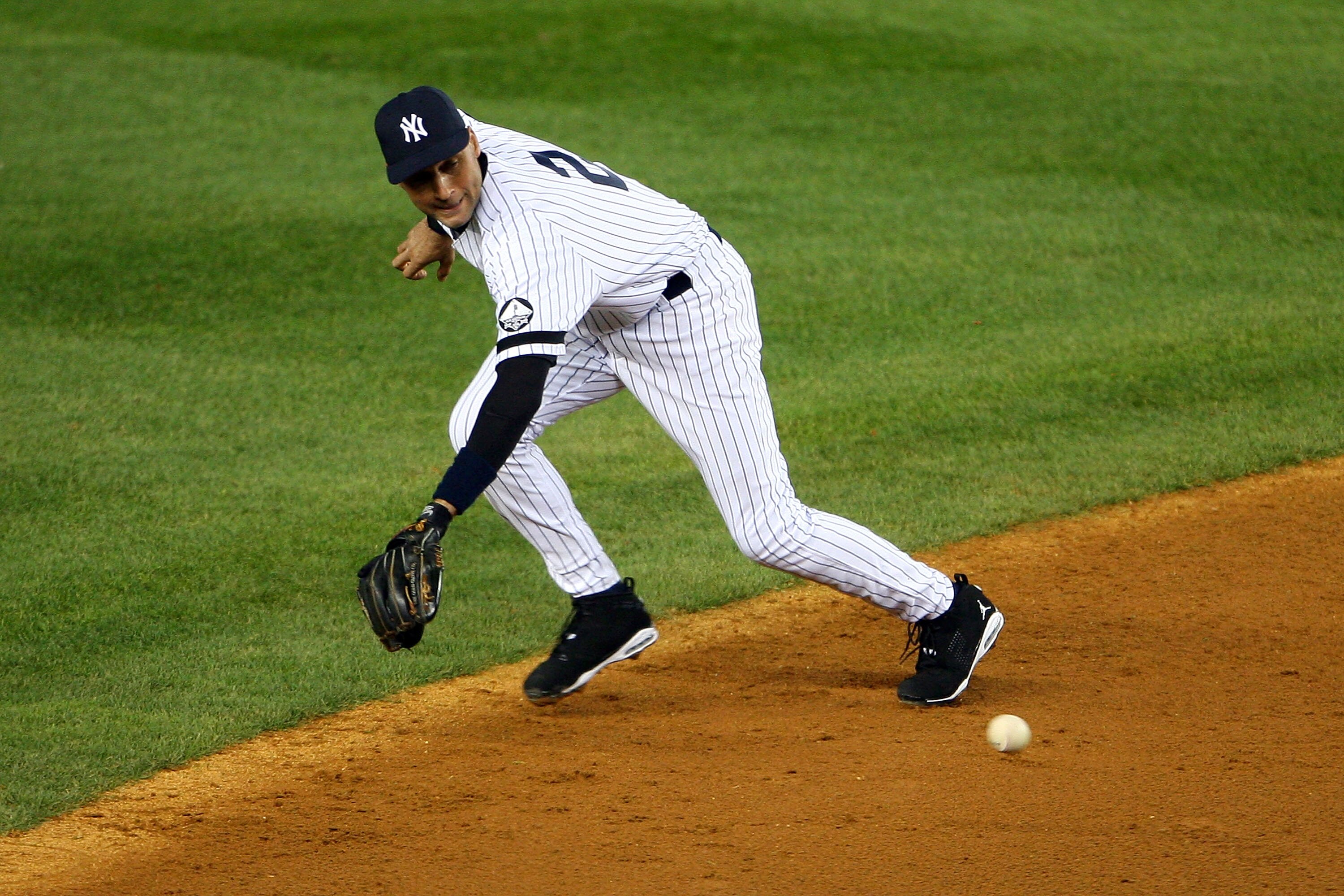 NEW YORK - OCTOBER 18:  Derek Jeter #2 of the New York Yankees fields an infield single hit by Michael Young #10 of the Texas Rangers in the top of the third inning of Game Three of the ALCS during the 2010 MLB Playoffs at Yankee Stadium on October 18, 20