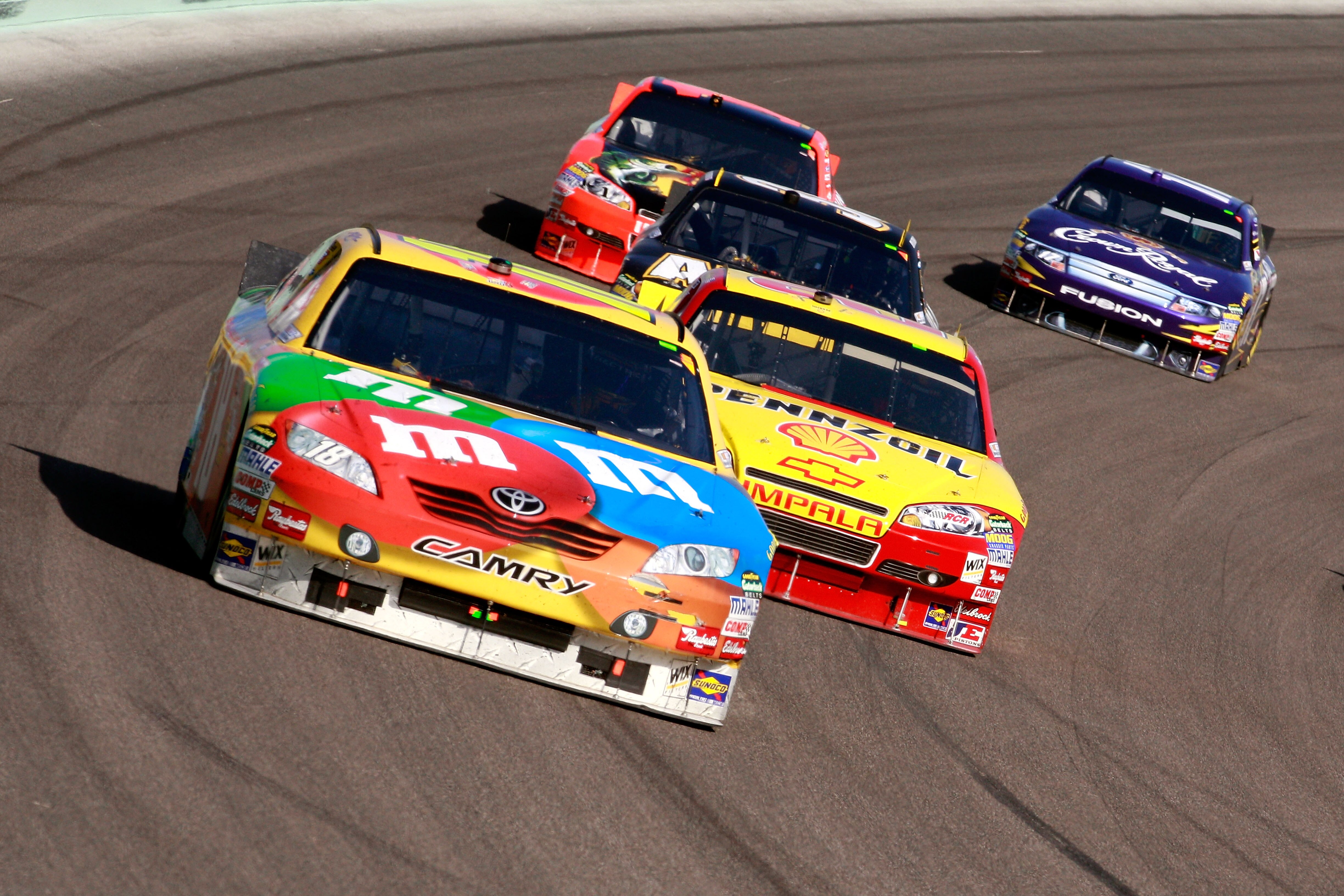 HOMESTEAD, FL - NOVEMBER 21:  Kyle Busch, driver of the #18 M&M'sToyota, leads Kevin Harvick, driver of the #29 Shell/Pennzoil Chevrolet, during the NASCAR Sprint Cup Series Ford 400 at Homestead-Miami Speedway on November 21, 2010 in Homestead, Florida. 
