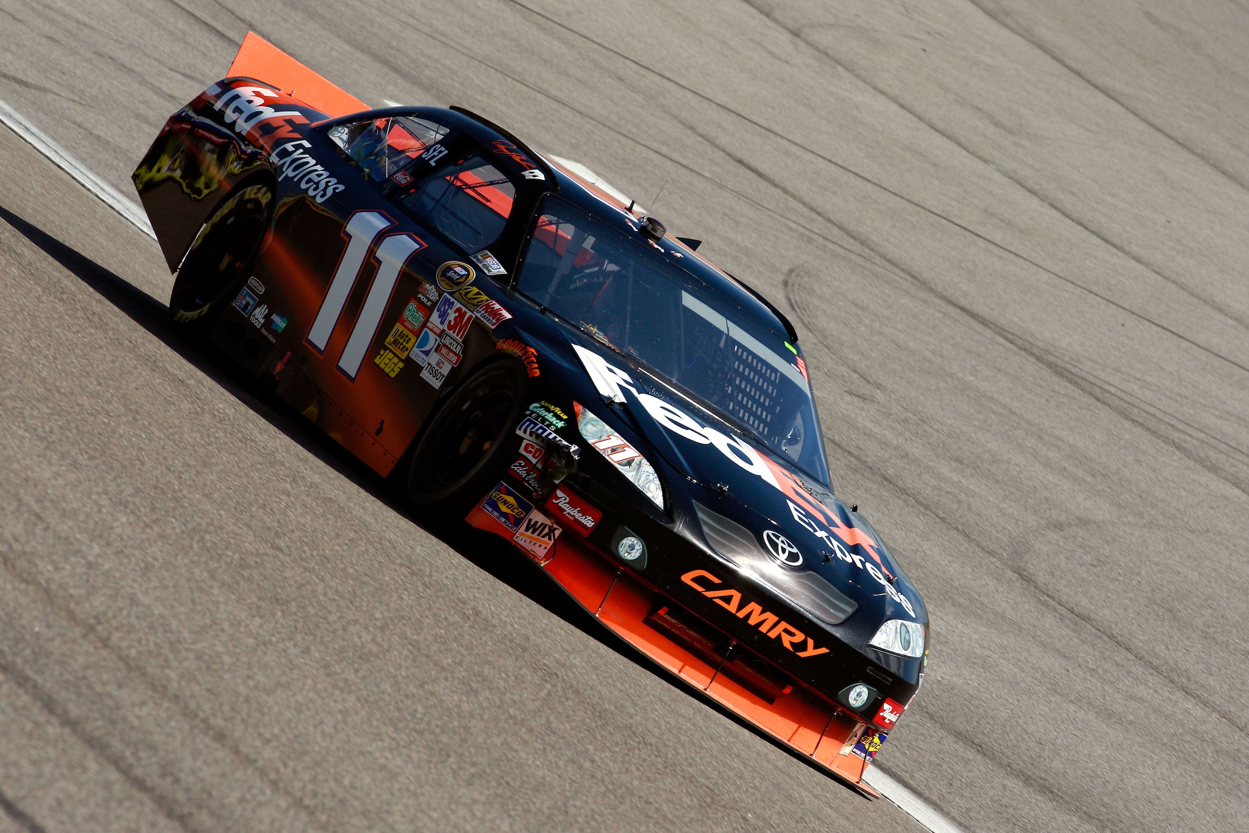 HOMESTEAD, FL - NOVEMBER 21:  Denny Hamlin, driver of the #11 FedEx Toyota, drives after sustaining front end damage during the NASCAR Sprint Cup Series Ford 400 at Homestead-Miami Speedway on November 21, 2010 in Homestead, Florida.  (Photo by Sam Greenw