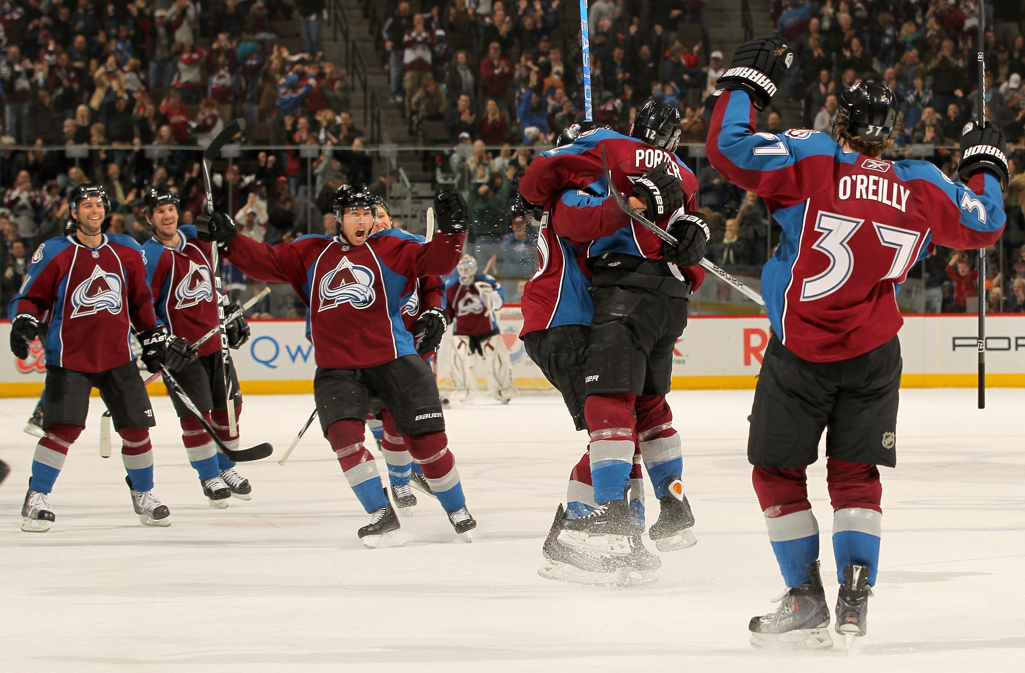 DENVER - NOVEMBER 17:  Kevin Porter #12 of the Colorado Avalanche jumps into the arms of Chris Stewart #25 as he celebrates his game winning goal in overtime against the San Jose Sharks as teammates Philippe Dupuis #11 (L) Scott Hannan #22 (2nd L), David