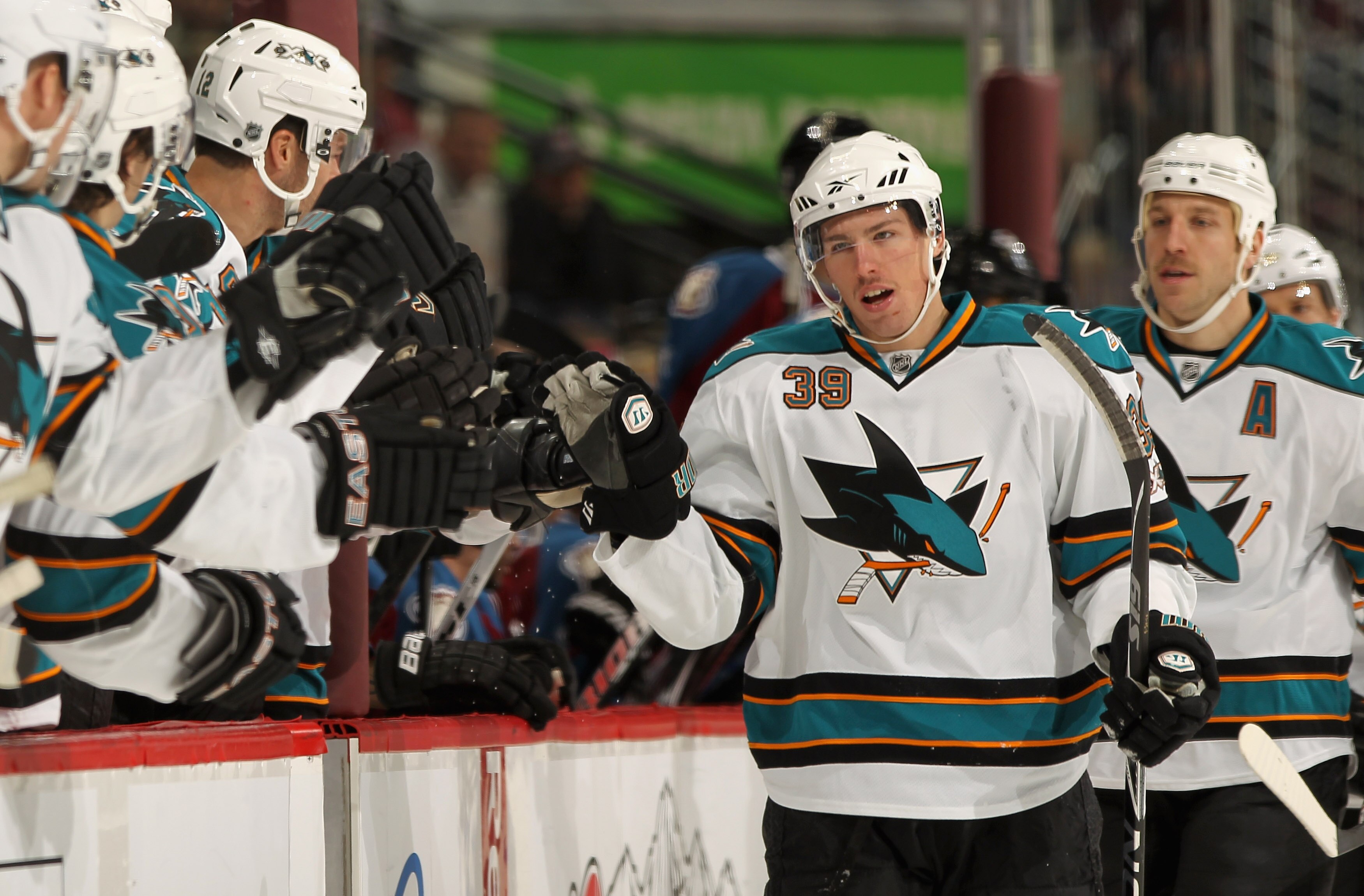 DENVER - NOVEMBER 17:  Logan Couture #39 of the San Jose Sharks heads to the bench to celebrate his goal along with Ryane Clowe #29 who earned an assist on the first period goal against the Colorado Avalanche at the Pepsi Center on November 17, 2010 in De
