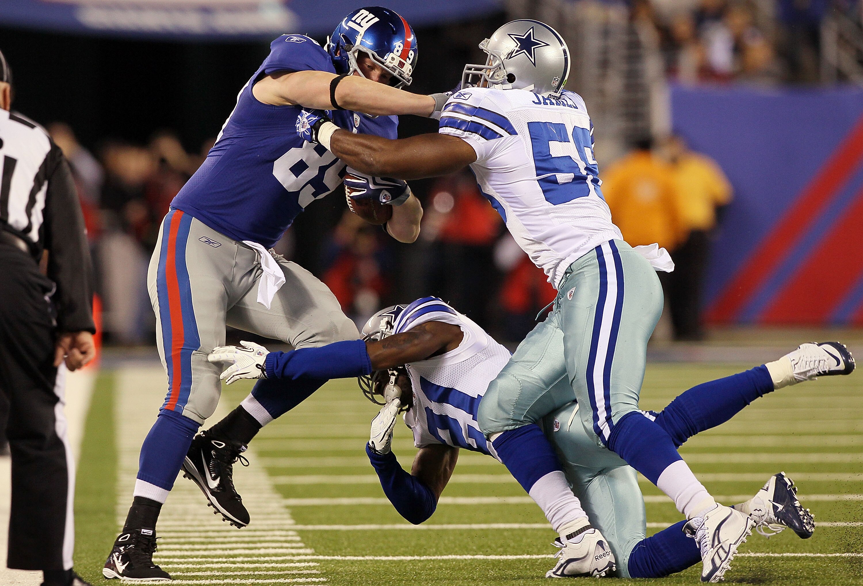 EAST RUTHERFORD, NJ - NOVEMBER 14:  Bradie James #56 and Mike Jenkins #21 of the Dallas Cowboys combine to stop Kevin Boss #89 of the New York Giants on November 14, 2010 at the New Meadowlands Stadium in East Rutherford, New Jersey. The Cowboys defeated