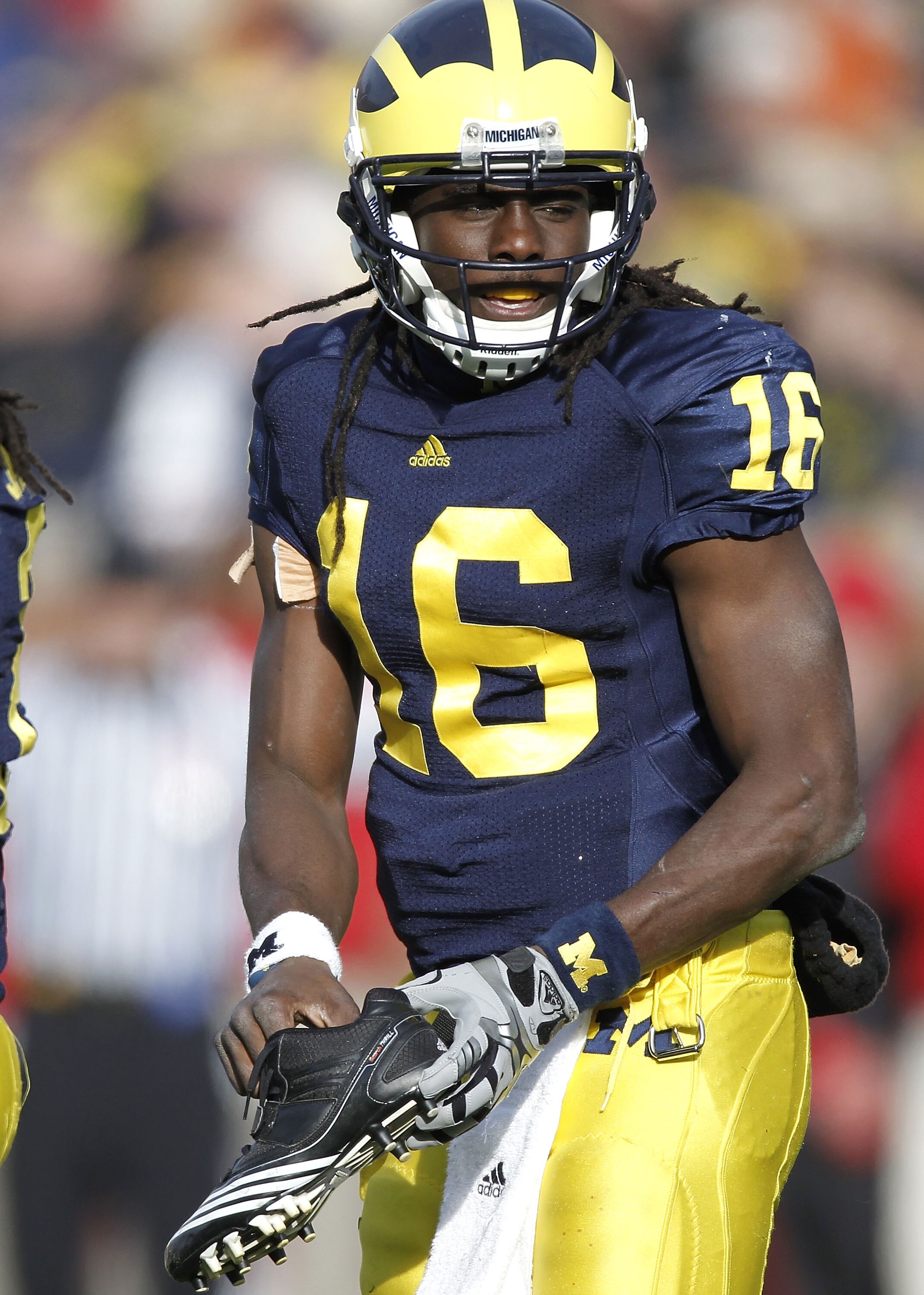 ANN ARBOR, MI - NOVEMBER 20:  Denard Robinson #16 of the Michigan Wolverines puts his shoe back on while playing the Wisconsin Badgers tackles at Michigan Stadium on November 20, 2010 in Ann Arbor, Michigan. Wisconsin won the game 48-38.  (Photo by Gregor
