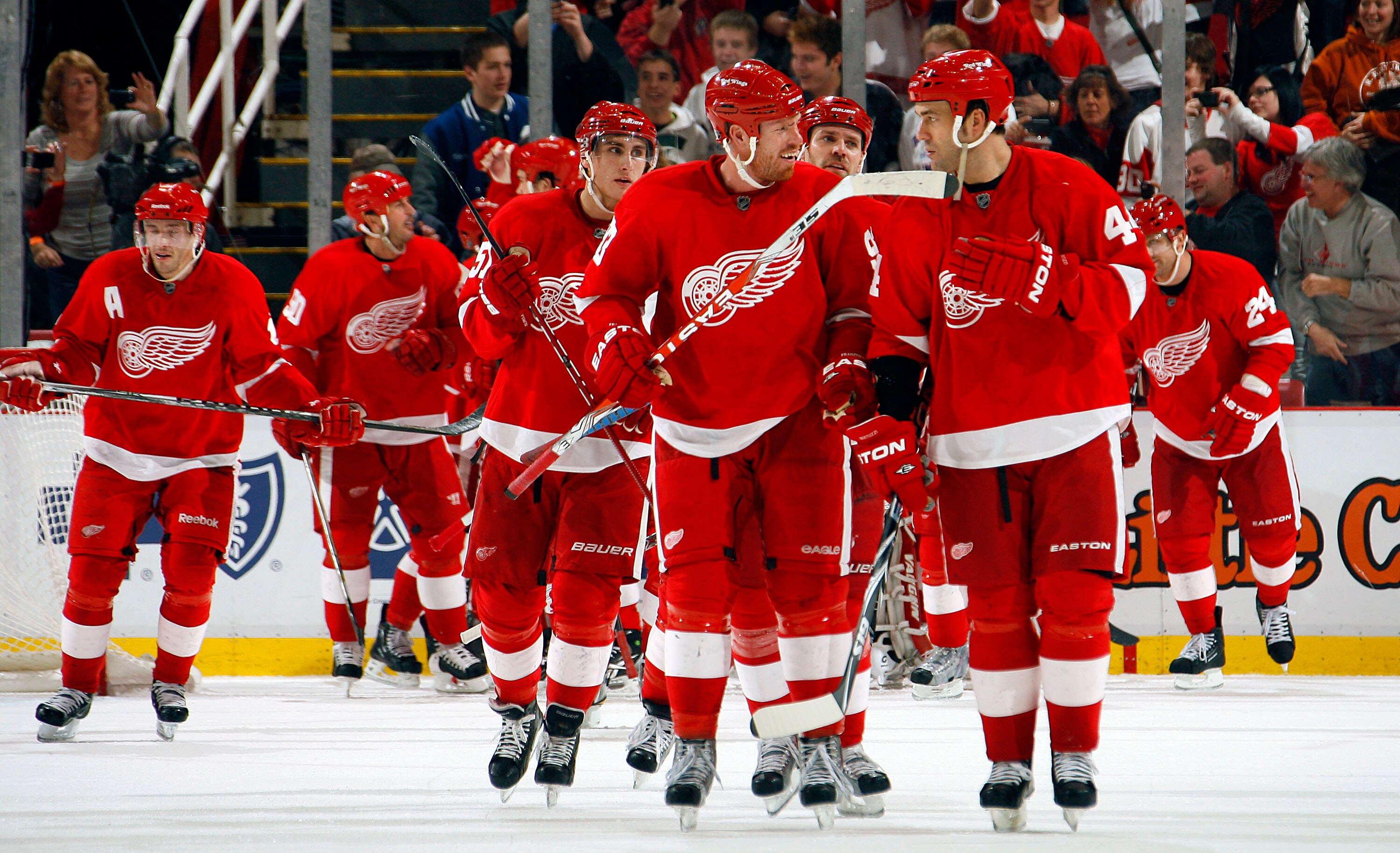 DETROIT - NOVEMBER 21:  Johan Franzen #93 and teammate Todd Bertuzzi #44 of the Detroit Red Wings lead their team off the ice as they celebrate a come from behind overtime victory during their NHL game at Joe Louis Arena on November 21, 2010 in Detroit, M