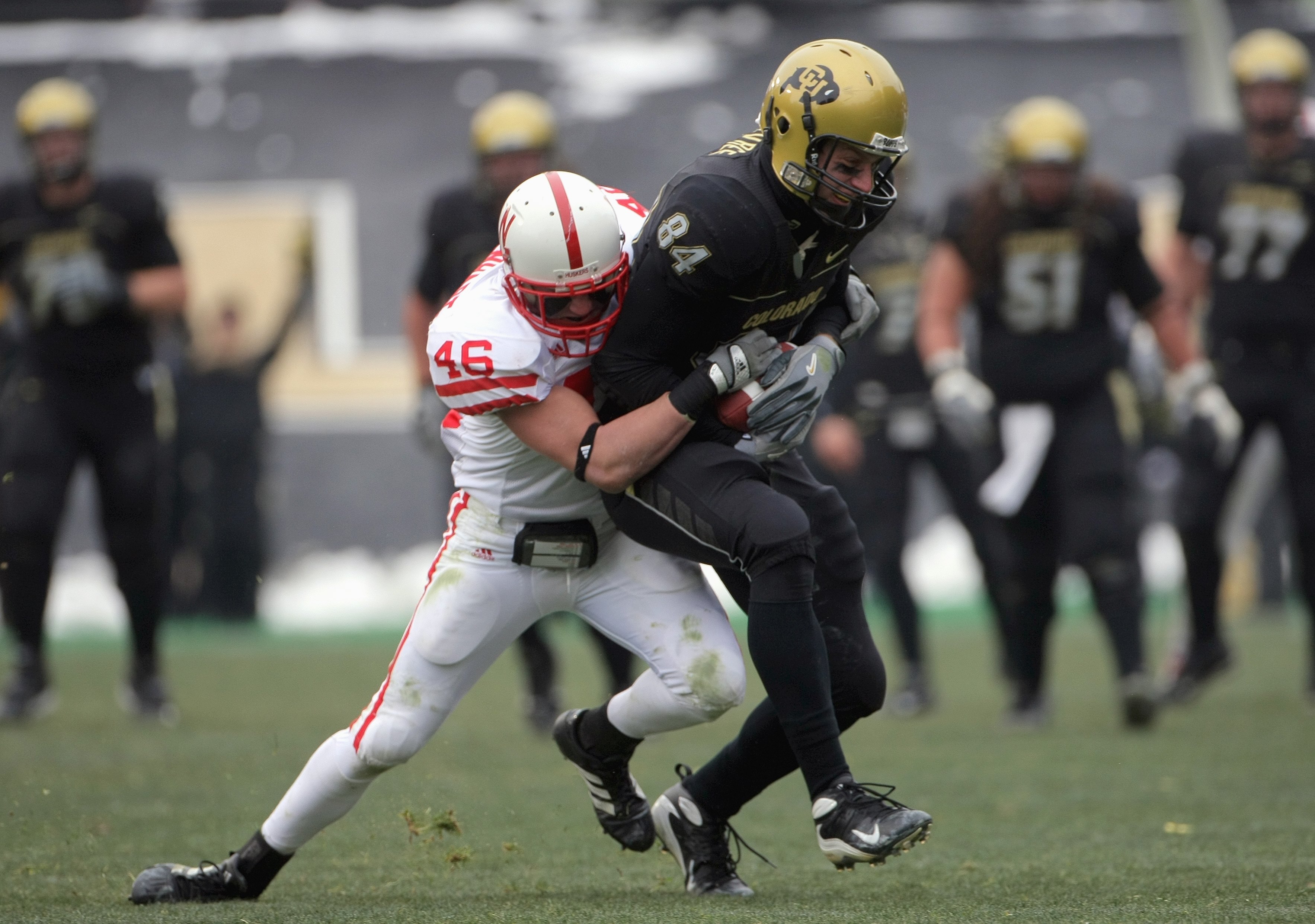 BOULDER, CO - NOVEMBER 23: Tyson DeVree #84 of the Colorado Buffaloes carries the ball as he is grabbed by Ben Eisenhart #46 of the Nebraska Cornhuskers during Big 12 College Football action at Folsom Field on November 23, 2007 in Boulder, Colorado. Color