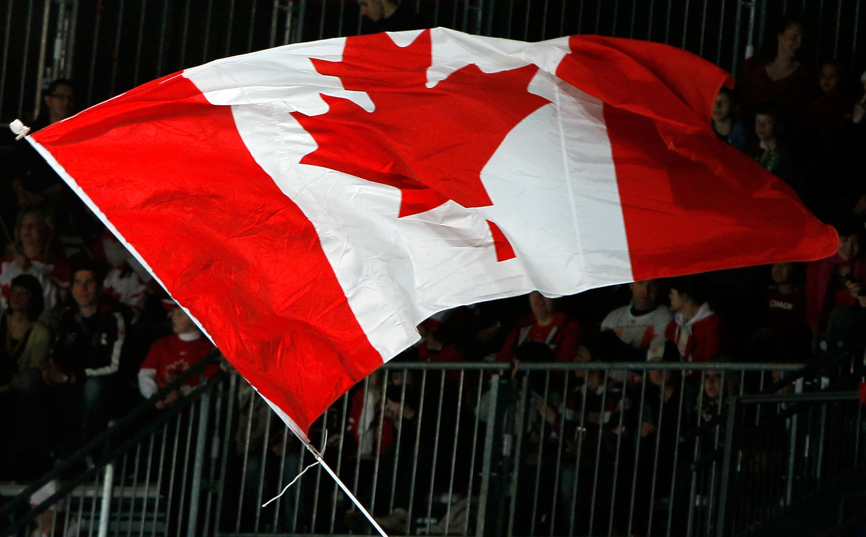 VANCOUVER, BC - MARCH 19:  A Canadian flag is waves in the air in support of Team Canada during the Ice Sledge Hockey Bronze Medal Game between Norway and Canada on day eight of the 2010 Vancouver Winter Paralympic Games at UBC Thunderbird Arena on March