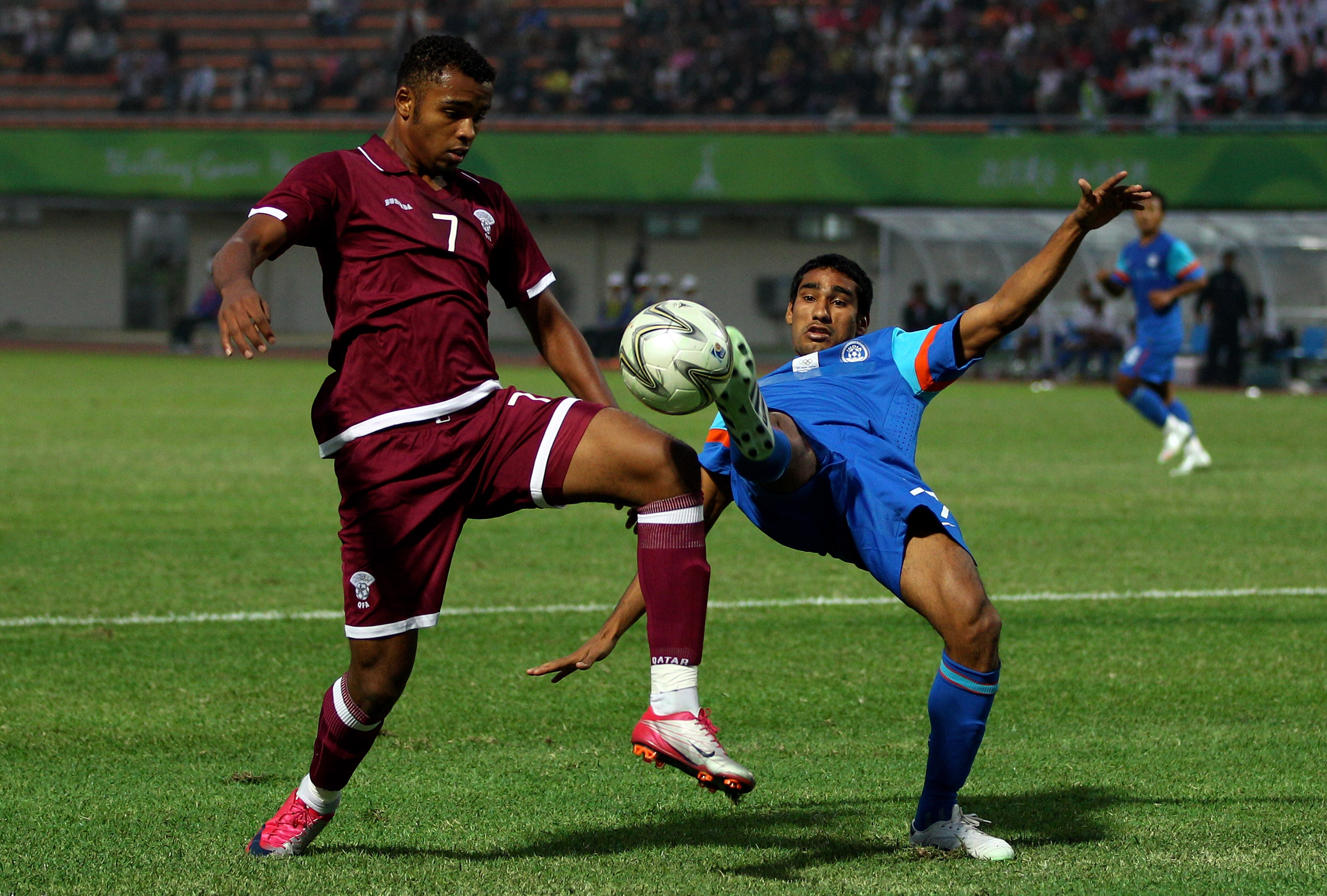GUANGZHOU, CHINA - NOVEMBER 09:  Khalfan Fahad of Qatar is tackled by Jagtar Singh of India during the Men's Football group D pool match between Qatar and India ahead of the 16th Asian Games Guangzhou 2010 at Huadu Stadium on November 9, 2010 in Guangzhou